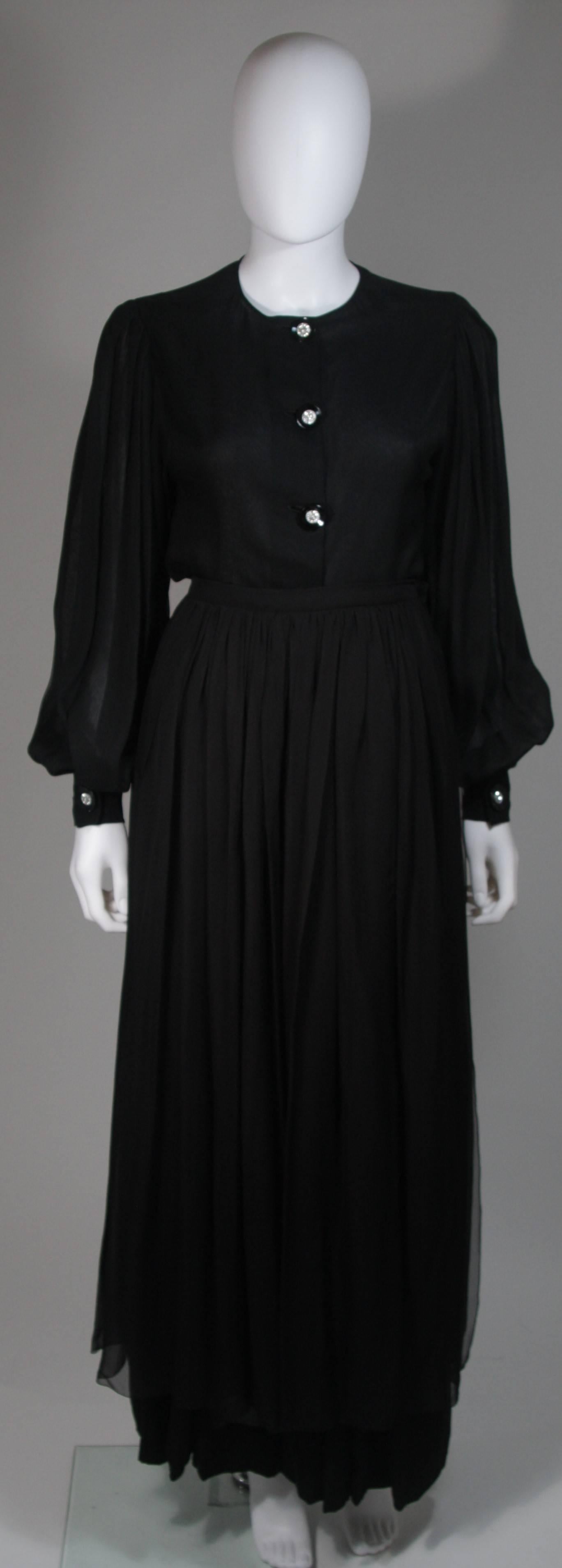 This Galanos  evening ensemble is composed of a black silk chiffon. Features three pieces. The blouse has rhinestone button closures. There is a semi sheer over skirt with a side closure. The pants feature a wide leg with side closure. In excellent