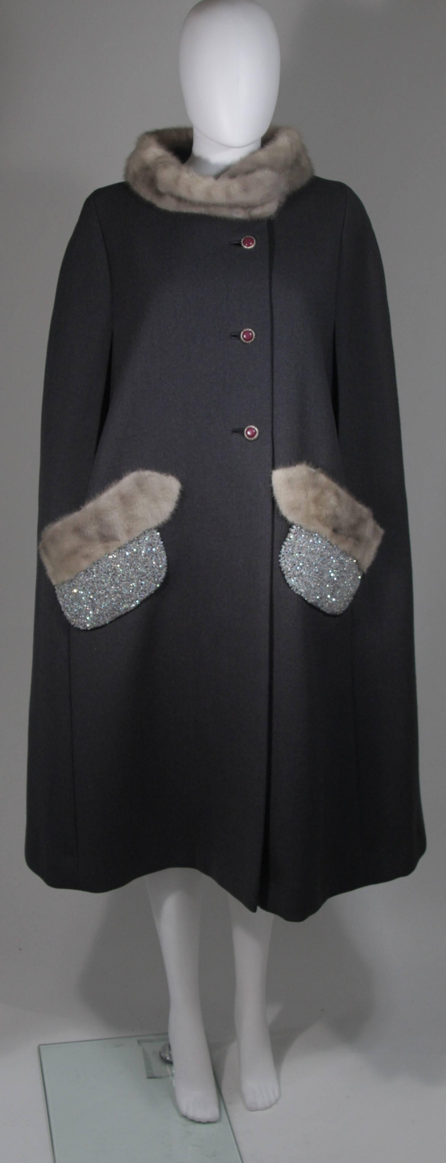  This cape is composed of a grey wool with mink trim. The cape is a vintage design with a modern twist, the iridescent beading at the pockets are a modern addition by 'Vutique'. The jacket has front button closures. In excellent vintage condition.