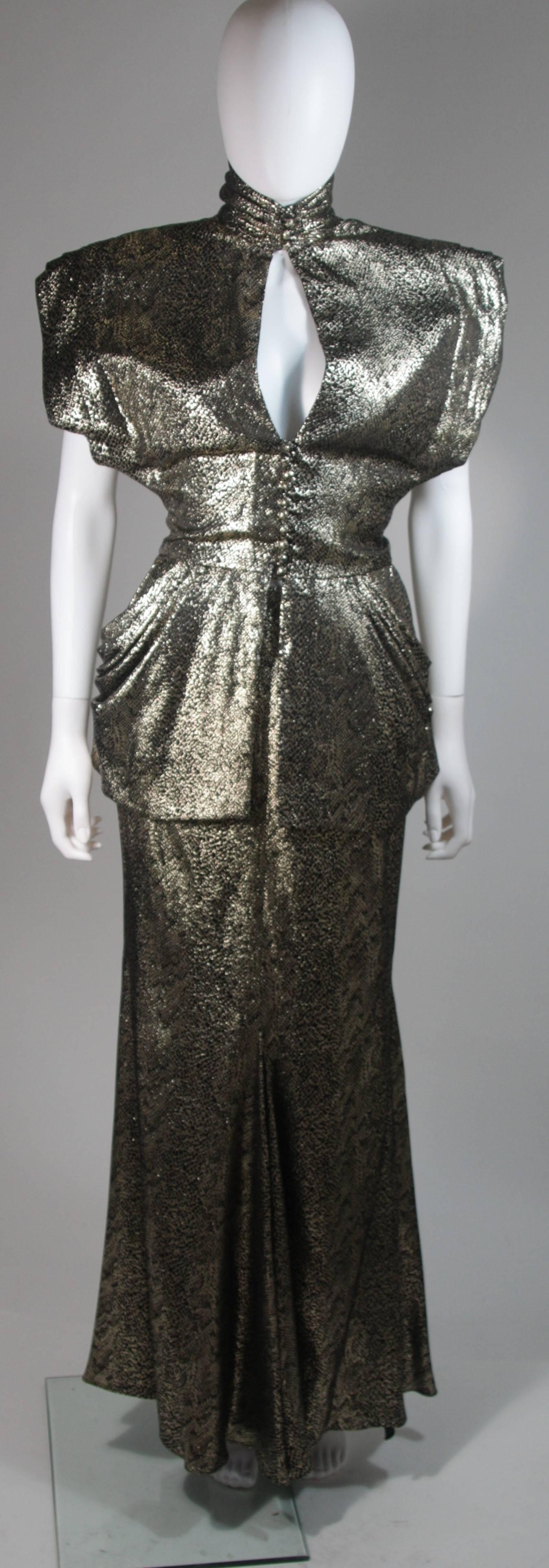 This Vicky Tiel ensemble is composed of a black silk with metallic snake print. The structured top features shoulder pads and an open center front keyhole with button closures. The skirt has a zipper closure. In excellent vintage condition.