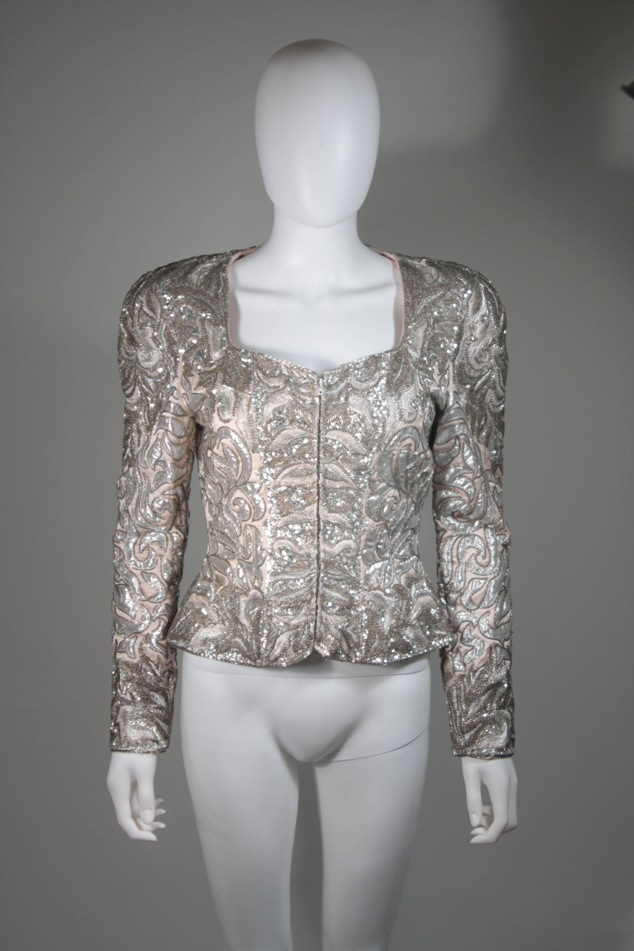 This Lacledes jacket is composed of an embellished pink silk. The jacket features silver beading throughout and a center front zipper. An amazing design and unique piece for any wardrobe. In excellent vintage condition.

  **Please cross-reference