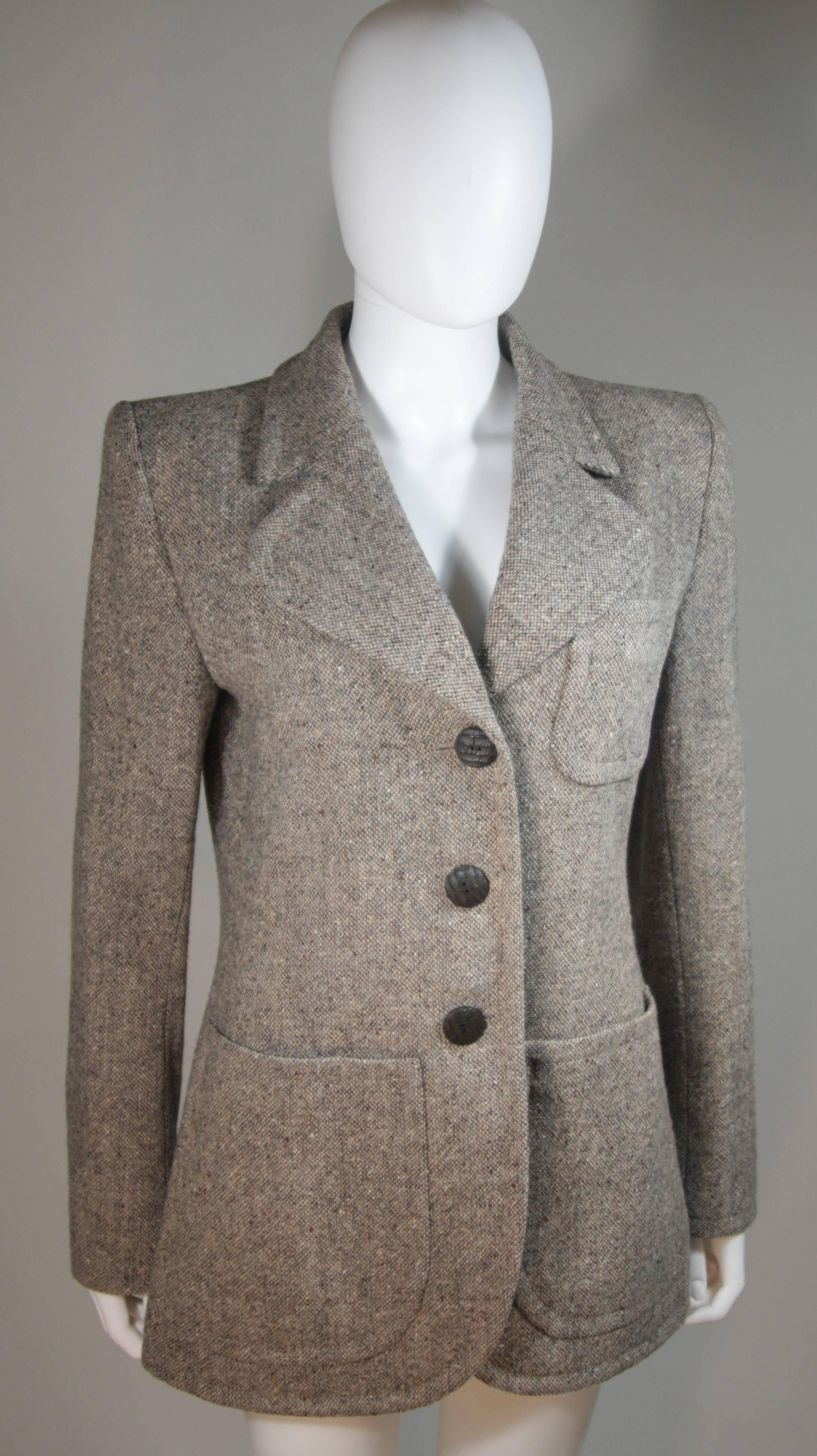 This Yves Saint Laurent design is available for viewing at our Beverly Hills Boutique. We offer a large selection of evening gowns and luxury garments. 

 This jacket is composed of wool and features wood buttons. The buttons feature a chisel