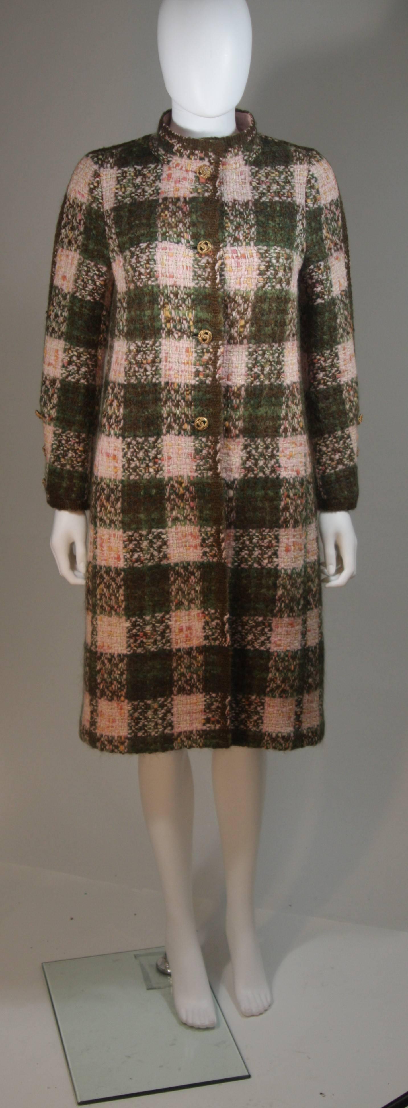 This Chanel Haute Couture design is available for viewing at our Beverly Hills Boutique. We offer a large selection of evening gowns and luxury garments. 

 This coat is composed of a green and pink boucle with a pink silk lining. Features Chanel