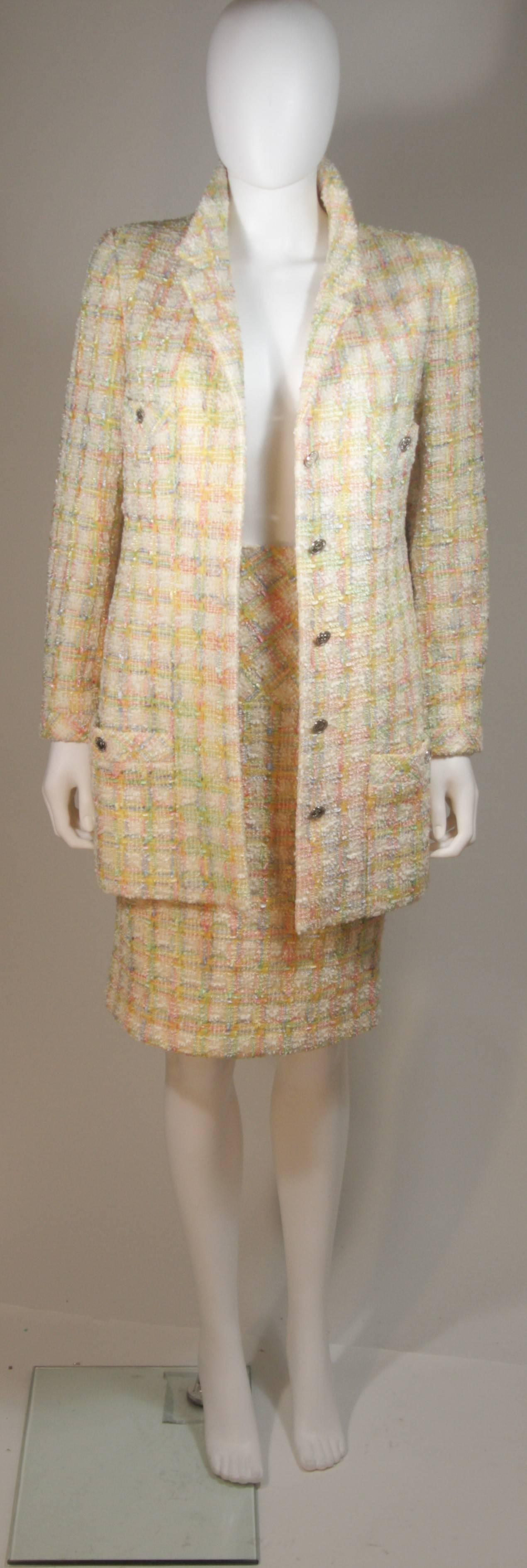 This Chanel design is available for viewing at our Beverly Hills Boutique. We offer a large selection of evening gowns and luxury garments. 

 This skirt suit is composed of a supple tweed boucle in pastel hues of cream, pink, yellow, and blue.