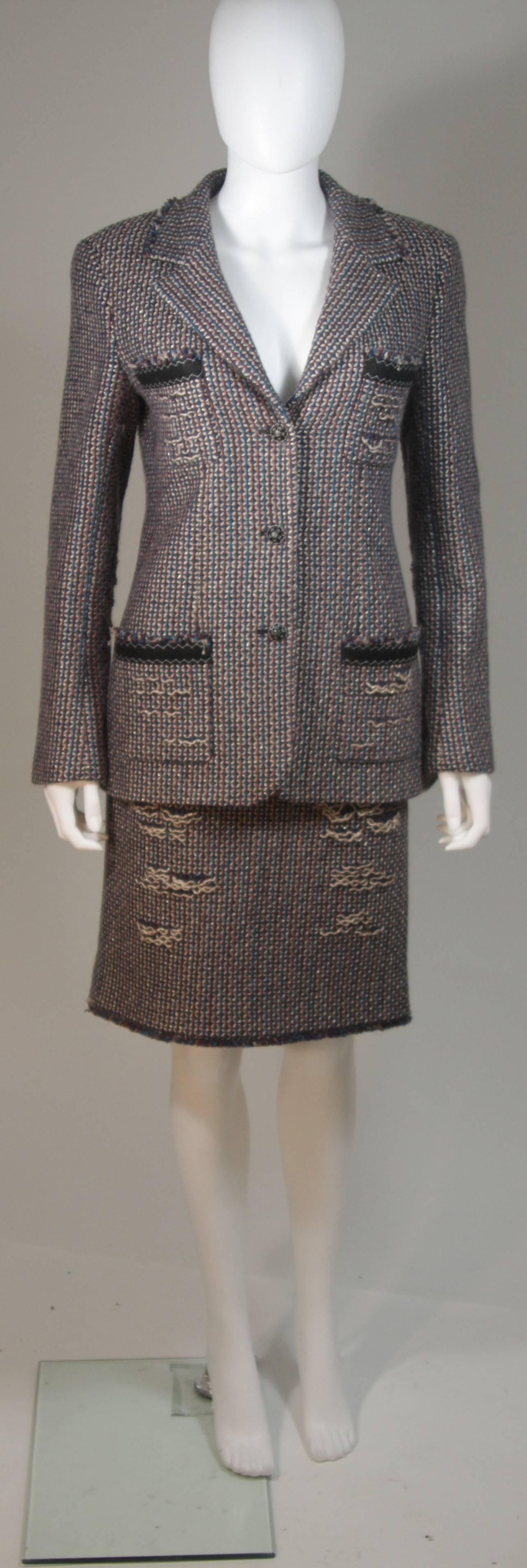 This Chanel skirt suit is composed of a multi color tweed with gold accents through out, complimenting the bas colors of burgundy and brown with blue. The jacket features front pockets with center front button closures. The skirt has a center back