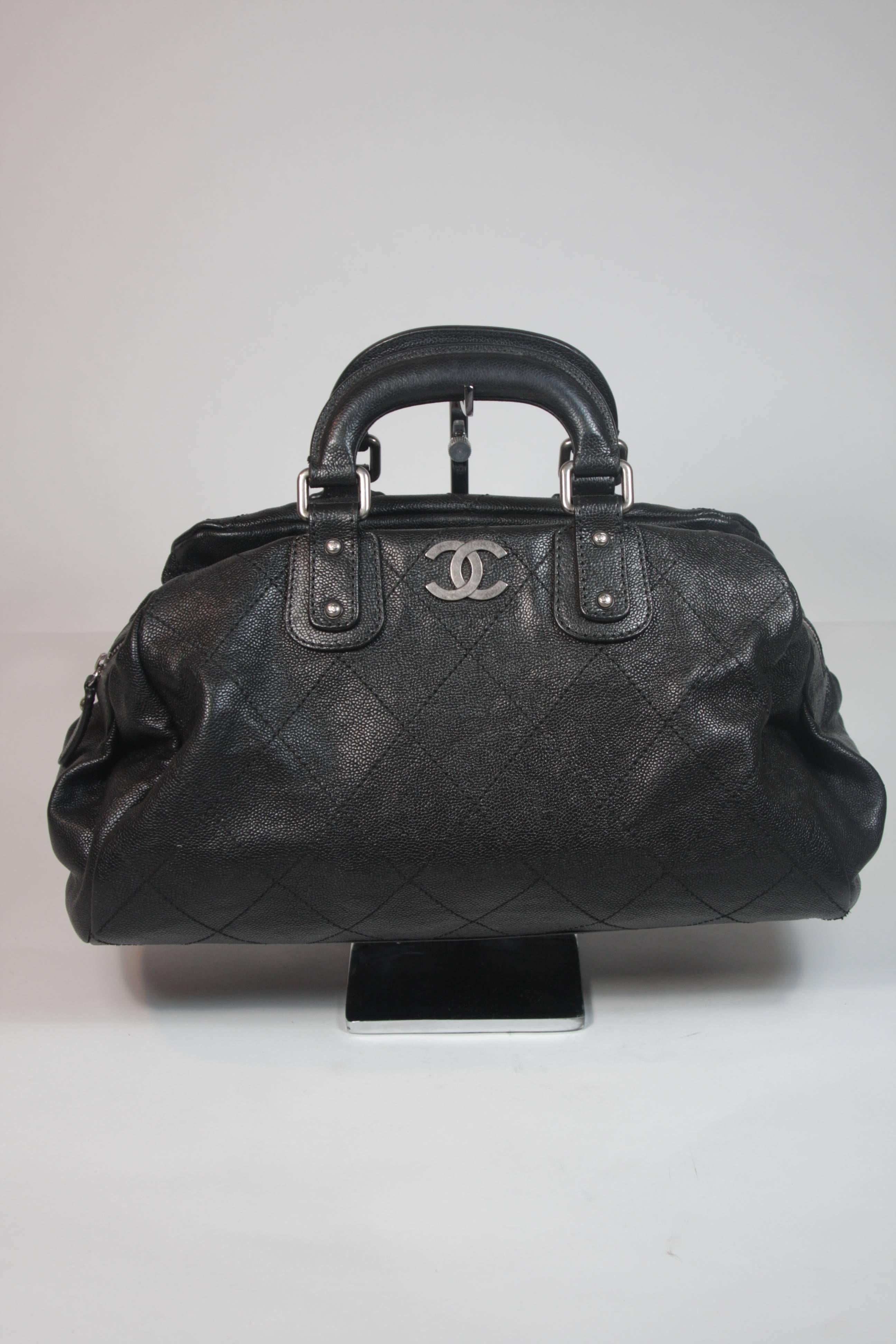 This Chanel handbag is composed of a black Caviar leather and features silver hardware with a zipper closure. In excellent condition. 

**Please cross-reference measurements for personal accuracy.

Measurements (Approximately)  
Length: