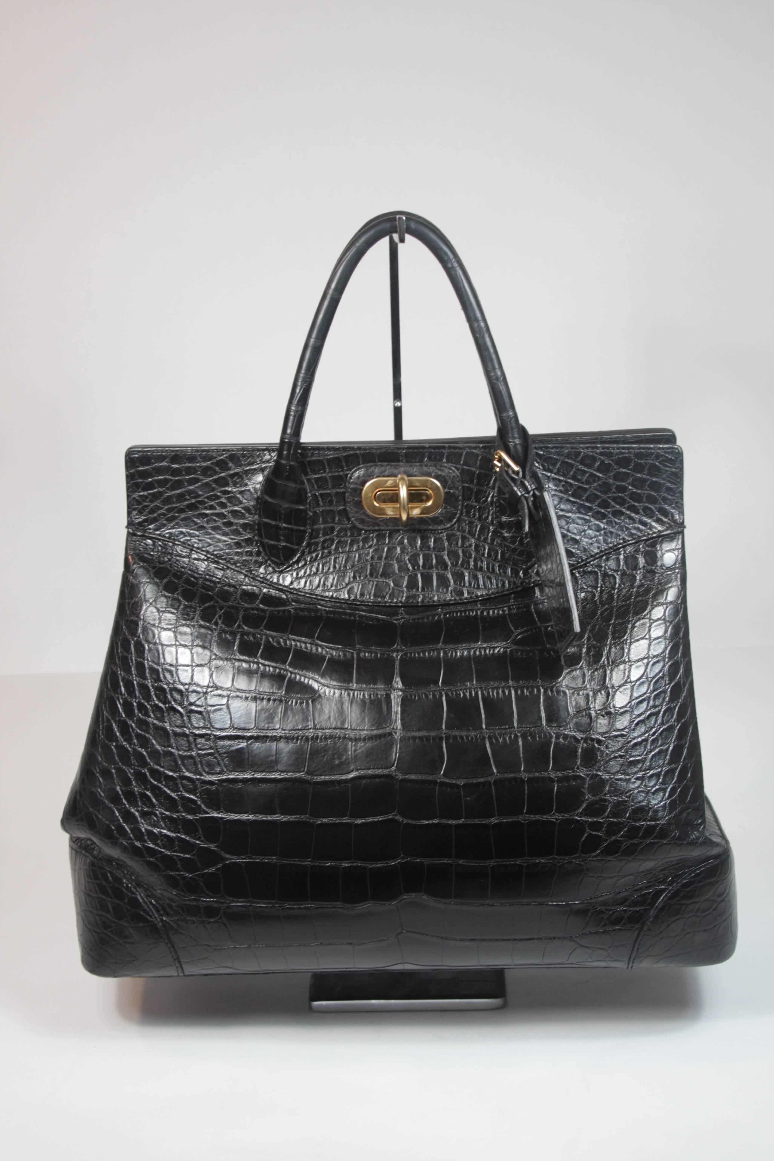 This Ralph Lauren design is available for viewing at our Beverly Hills Boutique. We offer a large selection of evening gowns and luxury garments. 

 This handbag is composed of a black alligator and features gold hardware. The double top handle