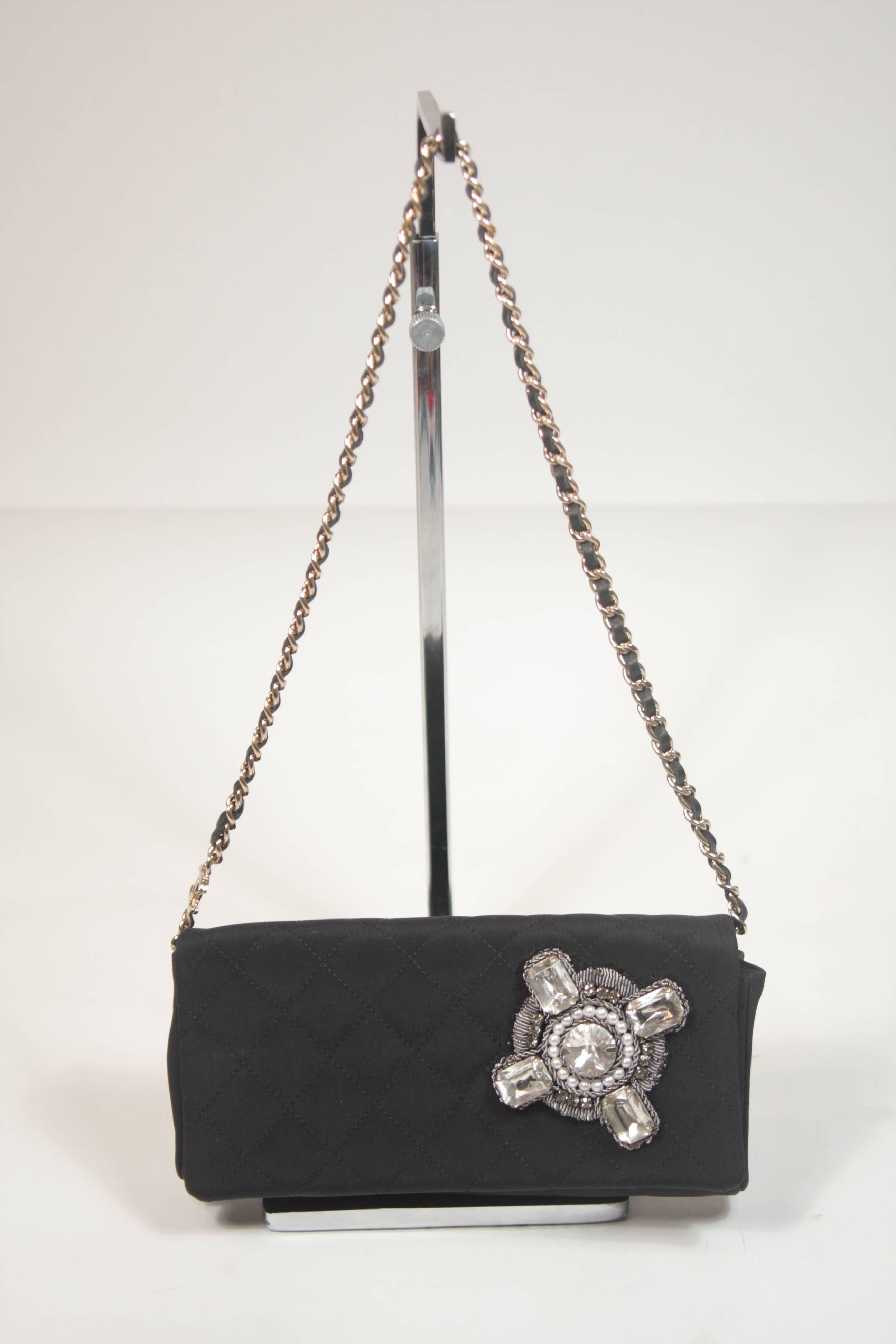 This Chanel design is available for viewing at our Beverly Hills Boutique. We offer a large selection of evening gowns and luxury garments. 

 This handbag is composed of a black quilted silk with rhinestone applique. Features the classic chain