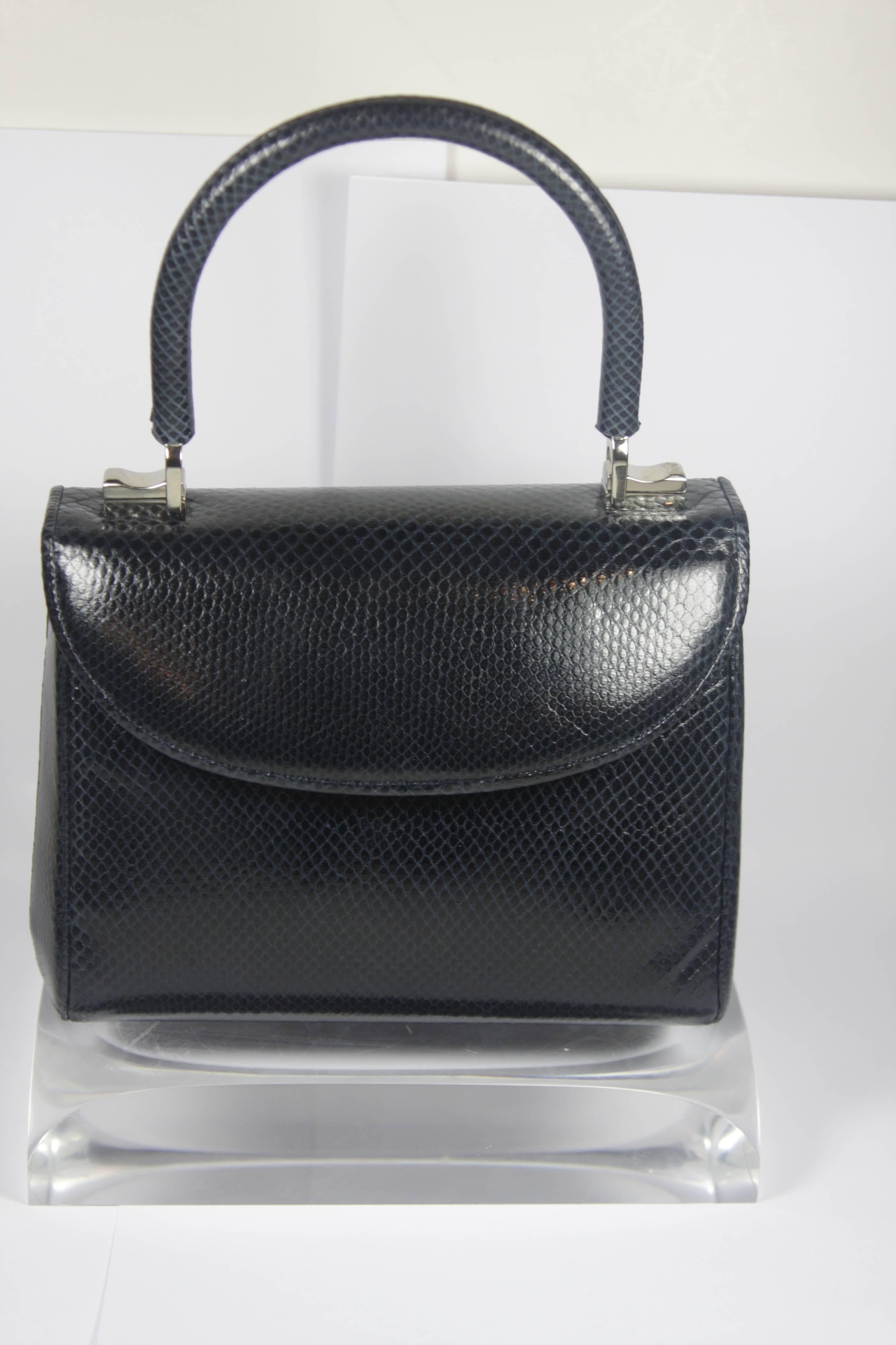 This Judith Leiber evening purse is composed of a navy lizard skin with silver hardware. There is a flap closure. In excellent condition, comes with original dustbag. 

  **Please cross-reference measurements for personal accuracy.