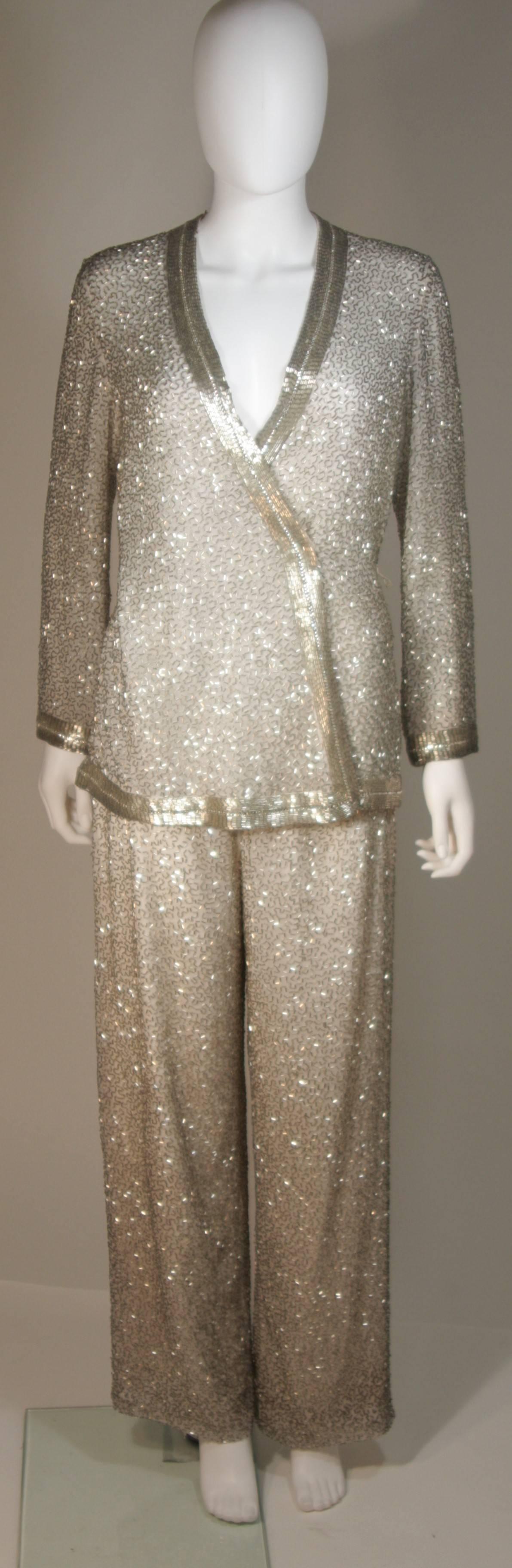 This vintage pant suit is composed of a off white silk with silver tone beading. The wrap style blouse features a plunging neckline and snap front, the sizing is optional by 2