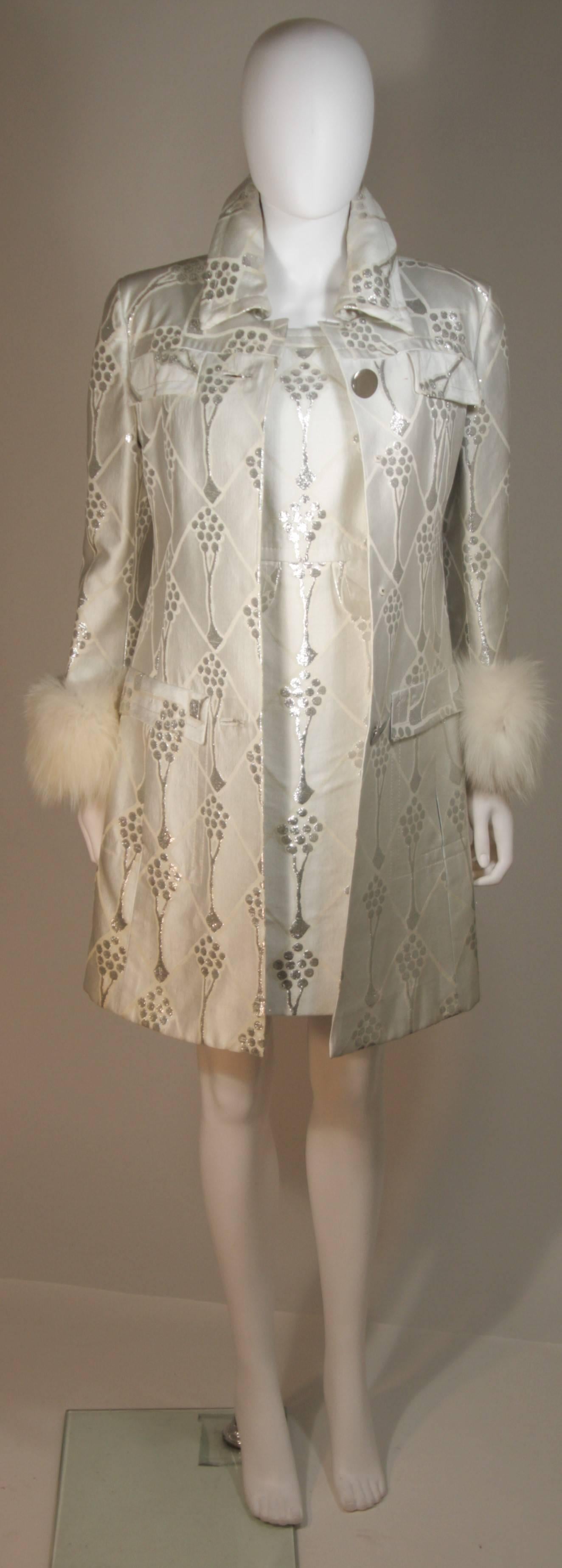 This Sorelle Fontana coat and dress set is composed of a white and silver metallic twill. The coat features a fox fur trim and center front button closures. The collar has a pliable metal detail so it may sit up right. The dress is a classic