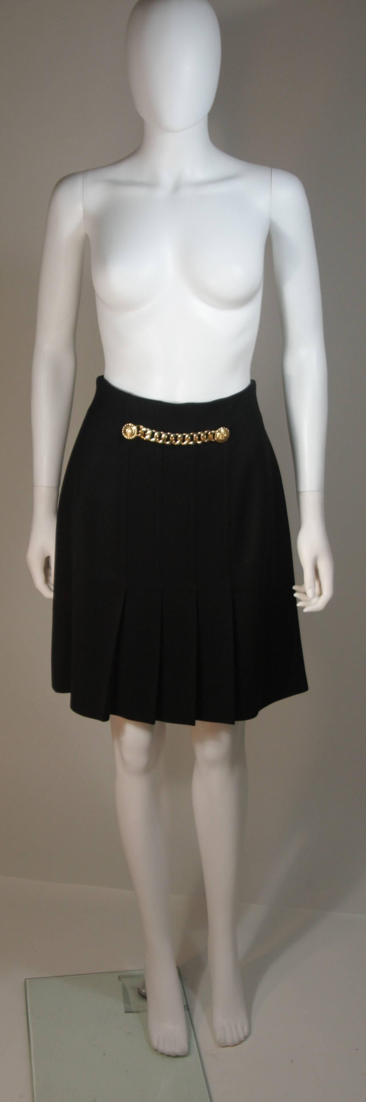 This Celine skirt is composed of a beautifully crafted black wool. The skirt features front pleats and a gold chain detail, There is a center back zipper closure. In excellent condition. Made in France.

  **Please cross-reference measurements for