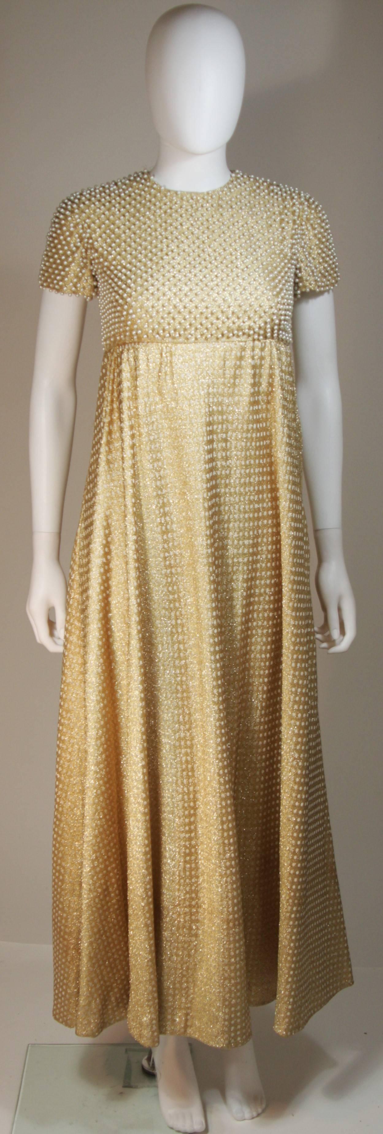 This Geoffrey Beene  gown is composed of a gold metallic knit with polka dot design, and hand beaded small pearl bodice. Gown is lined in soft white silk.
There are side pockets and a center back zipper closure with hook and eyes. 
In excellent