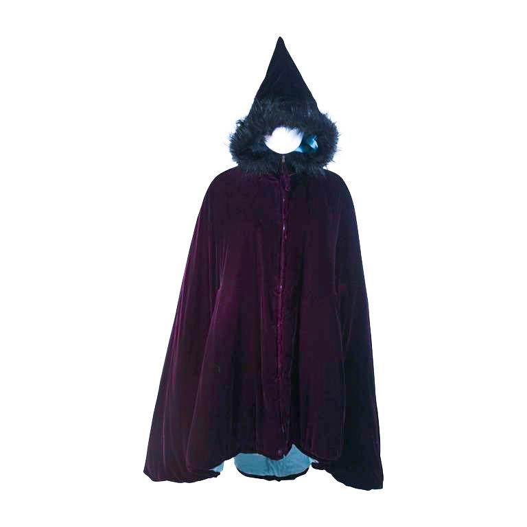 This Jean Paul Gaultier cape is composed of a purple velvet and features a baby blue lining. There is faux fur trim at the pointed hood. Features a center front zip closure. A very interesting design. In excellent condition, the baby blue lining has