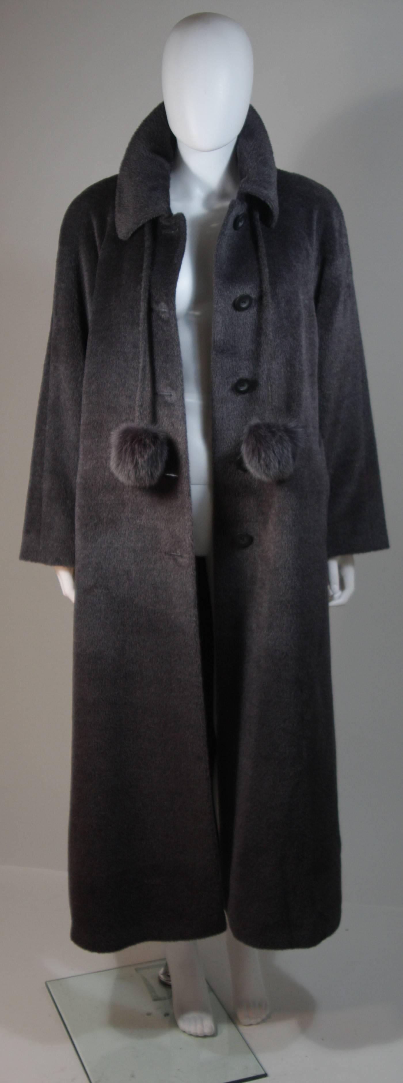 This Mallia Piacenza coat is composed of genuine grey baby Llama, which is very soft and supple. The coat features fox fur tassels and center front buttons. There are side pockets. In excellent condition. Made in Italy.

  **Please cross-reference