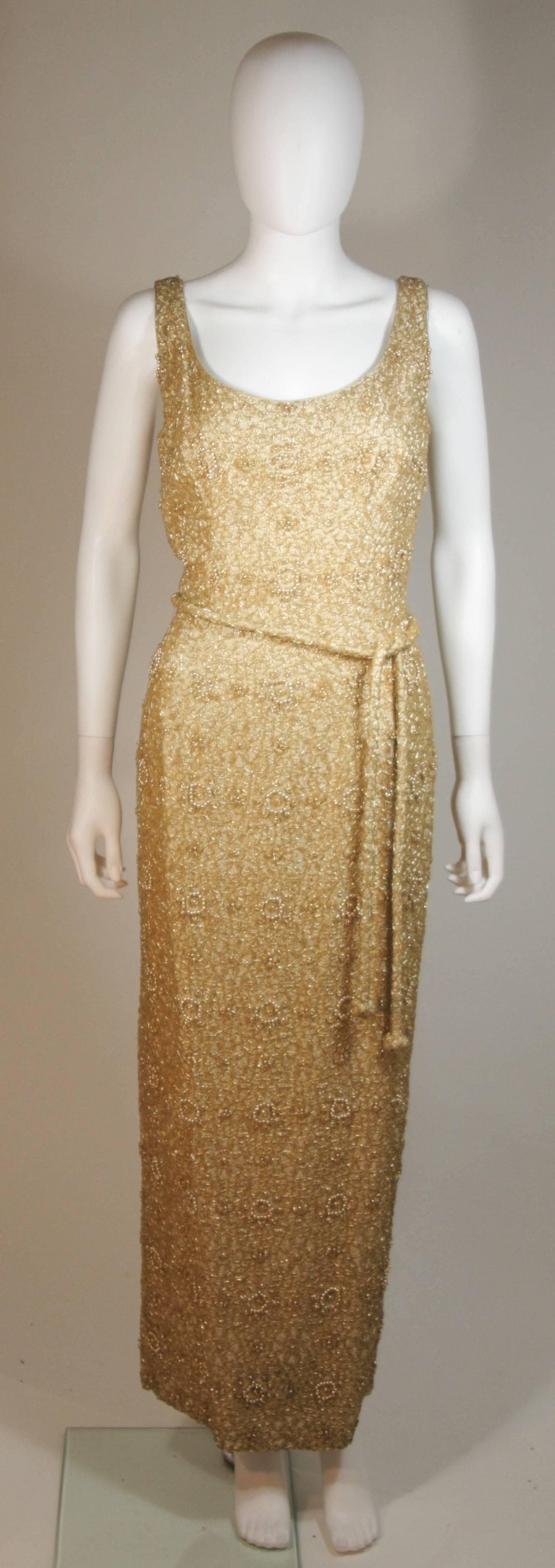 Diese Haute Couture Int'l  Das Kleid besteht aus einer stark perlenbesetzten Seide in Gold. Das Kleid hat einen klassischen Stil mit Reißverschluss und Gürtel. In ausgezeichnetem Vintage-Zustand. Hergestellt in Hongkong.

  **Bitte vergleichen Sie