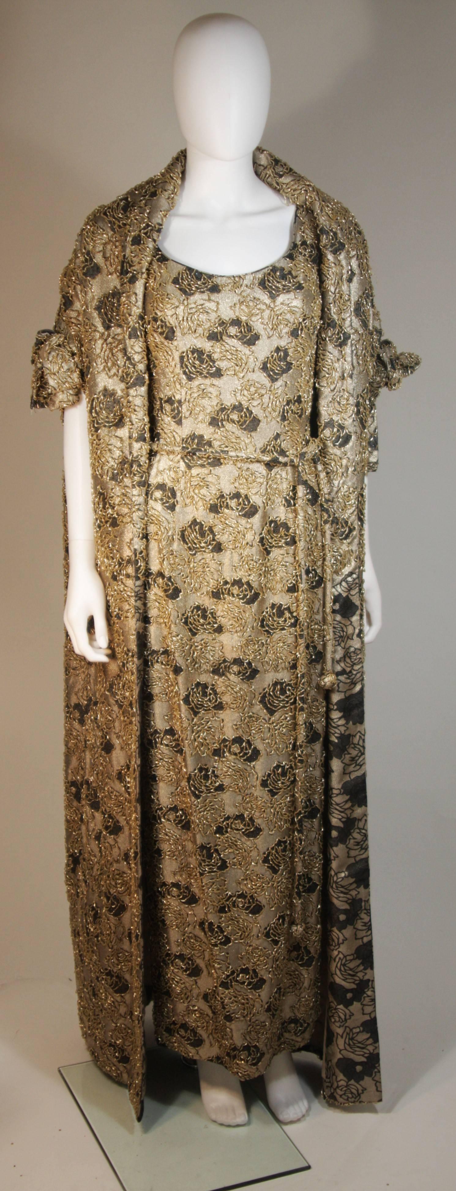 This Haute Couture Int'l  ensemble is composed of a beaded silk with floral motif in gold and black. The gown features a center back zipper and belt. The coat is a n open style with sleeve details. Lovely set. In excellent vintage condition, the