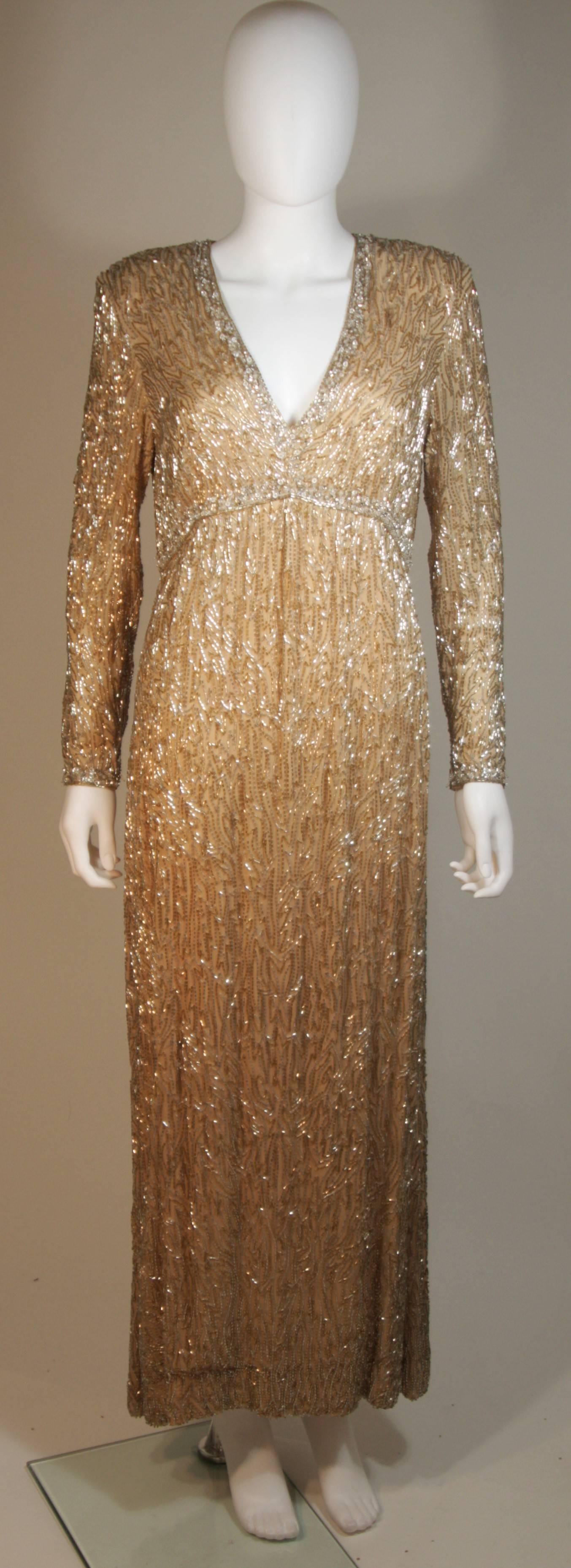 Dieses Victoria Royal  das Kleid besteht aus perlenbesetzter Seide in Champagnertönen mit Silber. Das Kleid hat einen tiefen Ausschnitt und lange Ärmel. Es gibt einen Reißverschluss in der Mitte des Rückens. In ausgezeichnetem Vintage-Zustand.

 