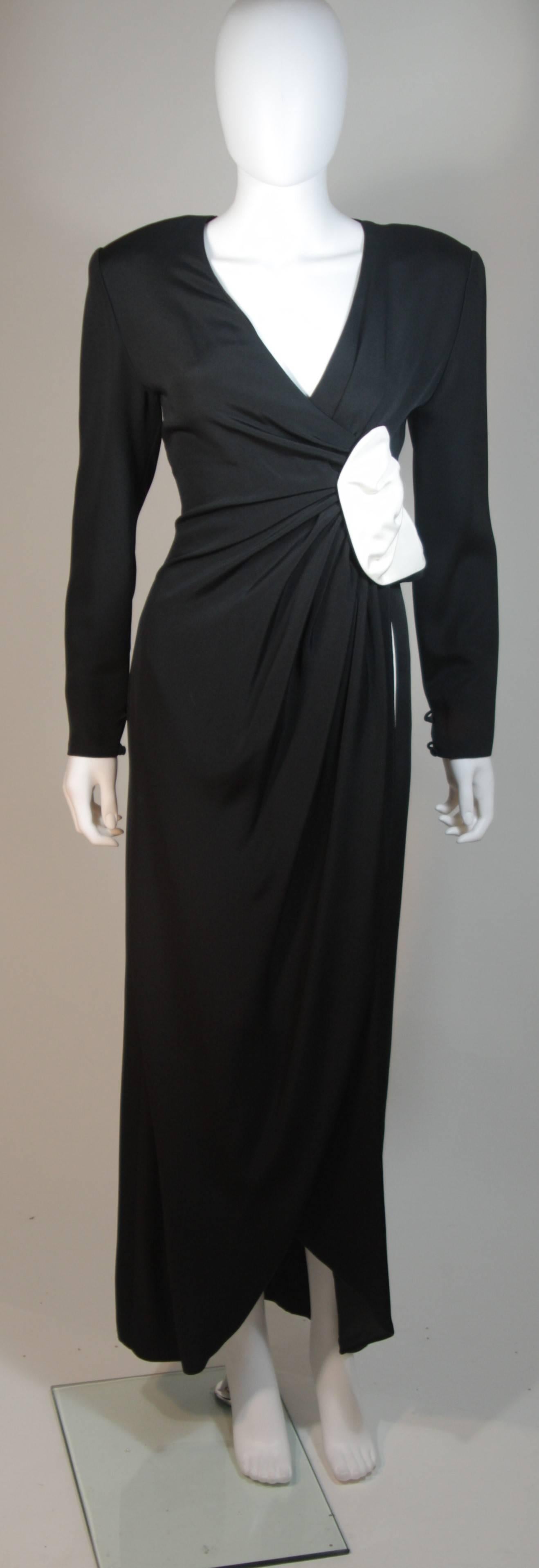 This Nolan Miller  gown is composed of black and white silk. The drape detail is accentuated by the striking contrast. The draped design contours the waist in a lovely way. There is a center back zipper closure. Circa 1980's.  In excellent