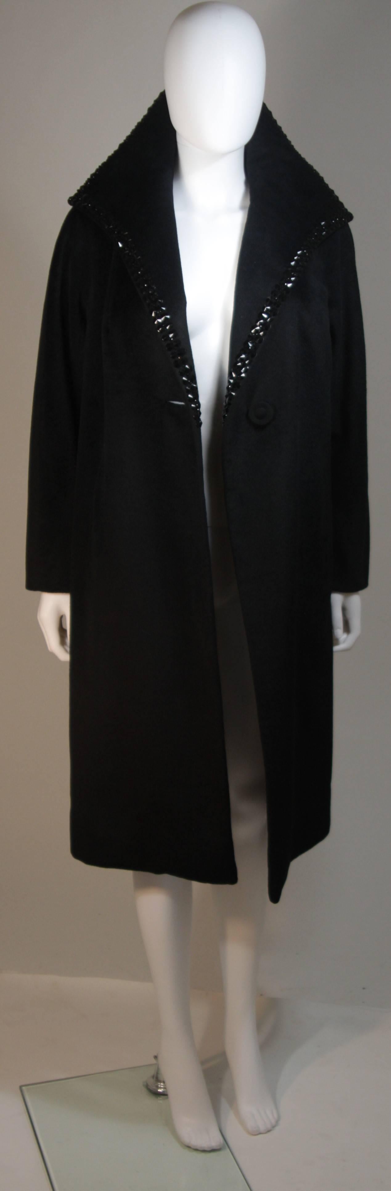 This McCalls Co.  coat is composed of a black wool and features a large collar. The collar has studded applique, applied by a contemporary designer. In excellent condition. Made in France.

  **Please cross-reference measurements for personal