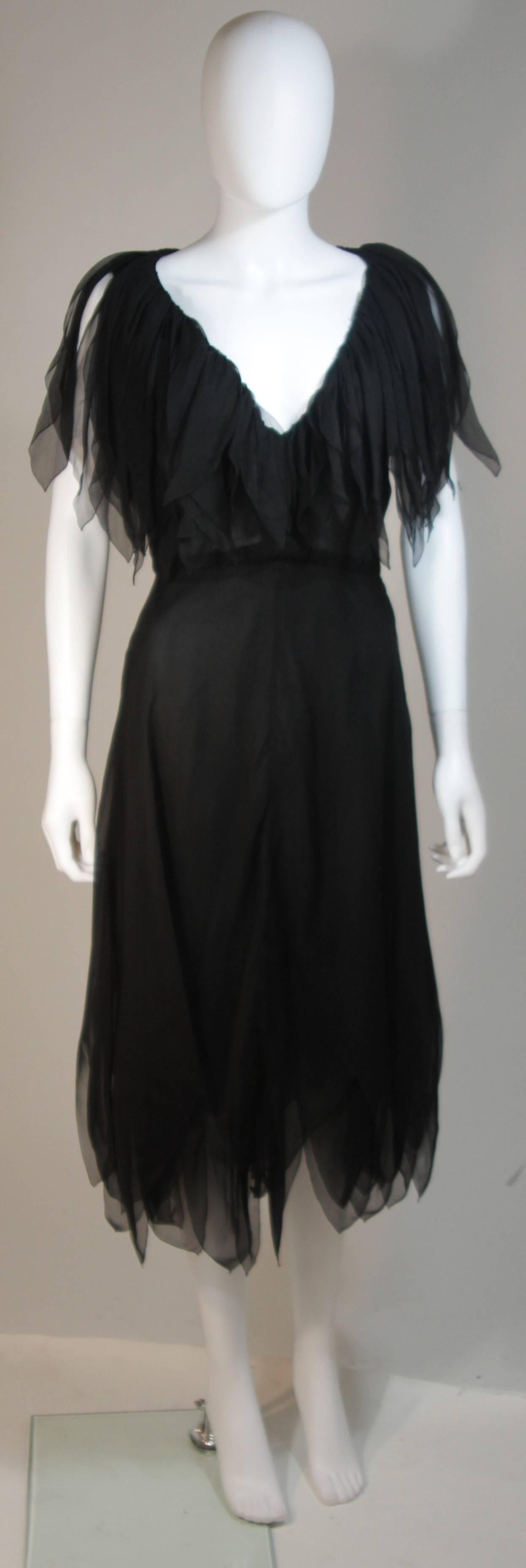 This Christian Dior design is available for viewing at our Beverly Hills Boutique. We offer a large selection of evening gowns and luxury garments. 

 This cocktail dress is composed of a layered black silk chiffon with fluttery strips at the