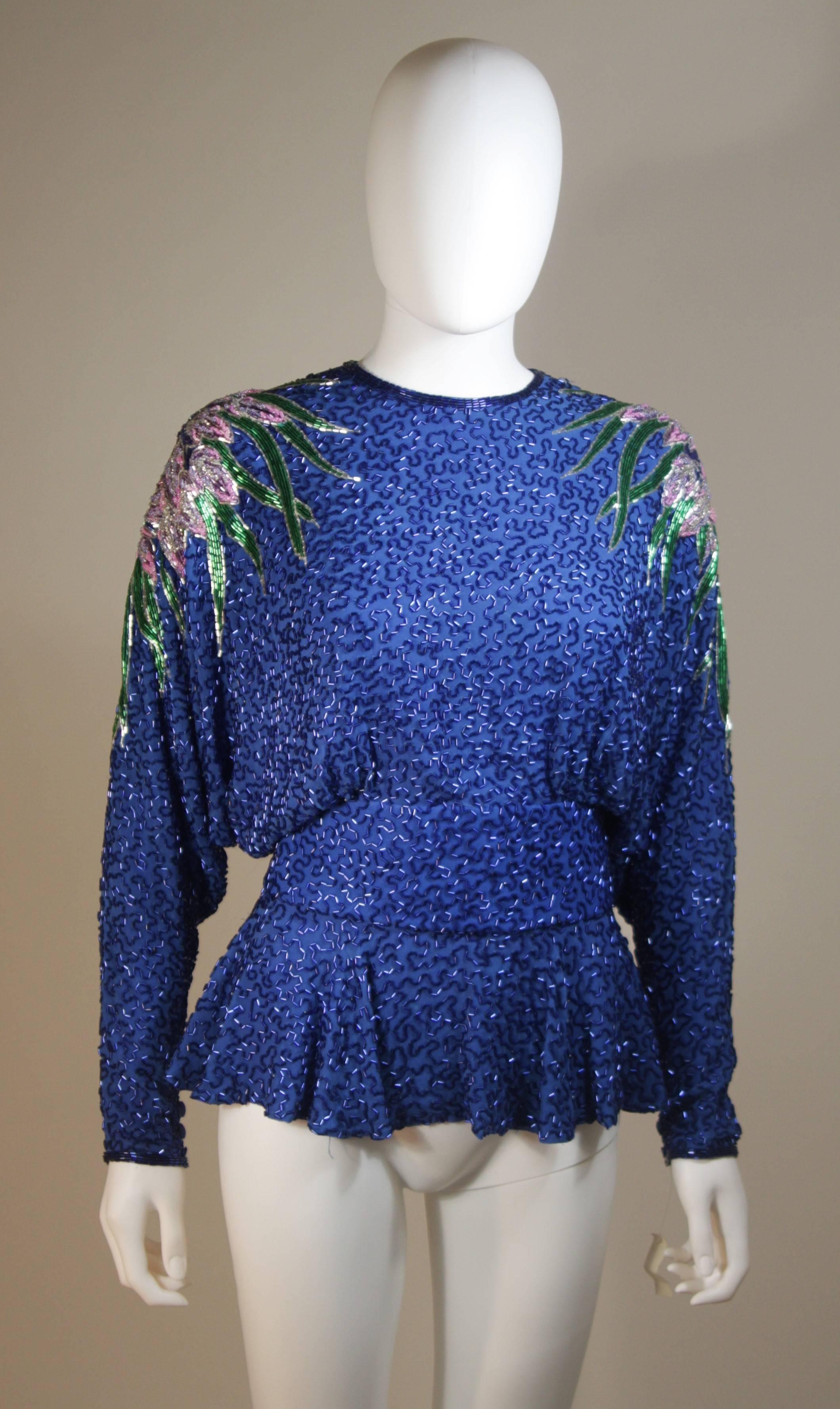 This Stephen Yearik top is composed of a heavily embellished silk top with dolman style sleeves in a vibrant blue hue. There are center back button closures. In great vintage condition.

  **Please cross-reference measurements for personal accuracy.