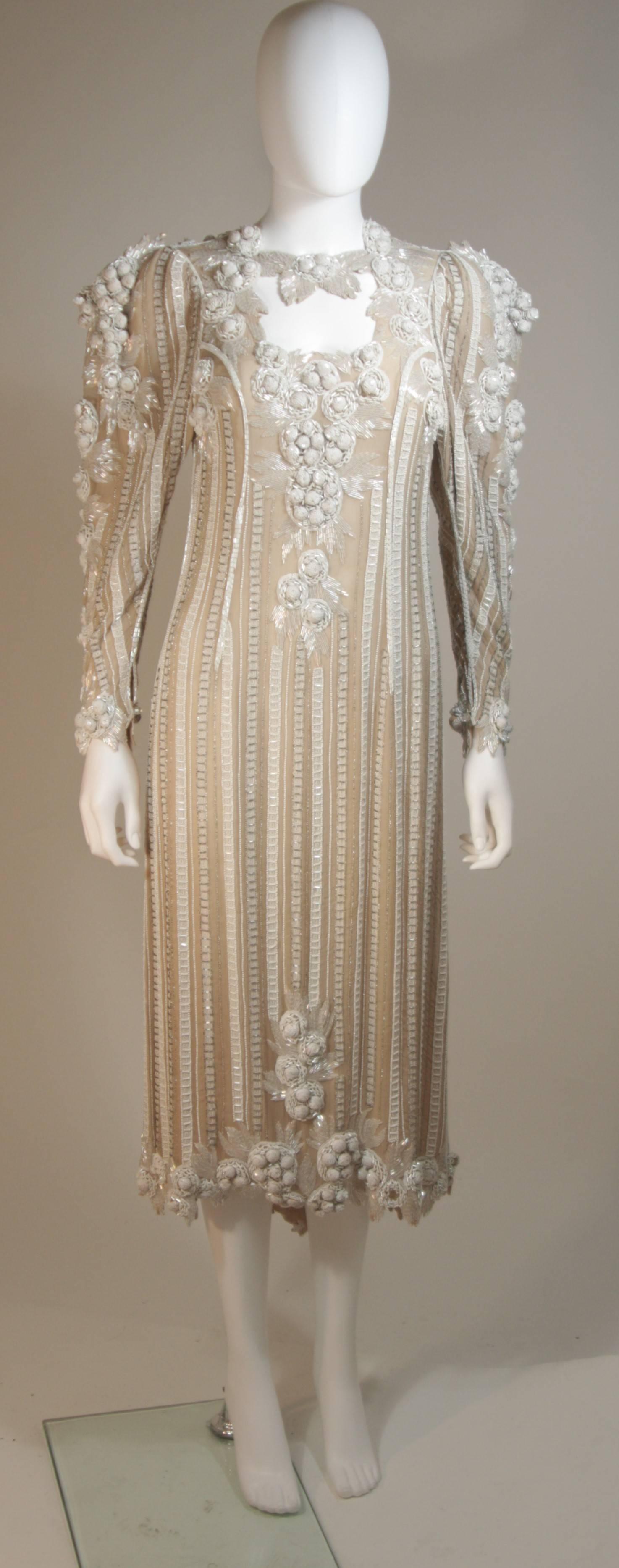  This dress is composed of a beaded ivory silk. Features amazing bead and sequin applique with relief beading and dimensional shouldler details. There are center back button closures. In great vintage condition. Made in England.

  **Please