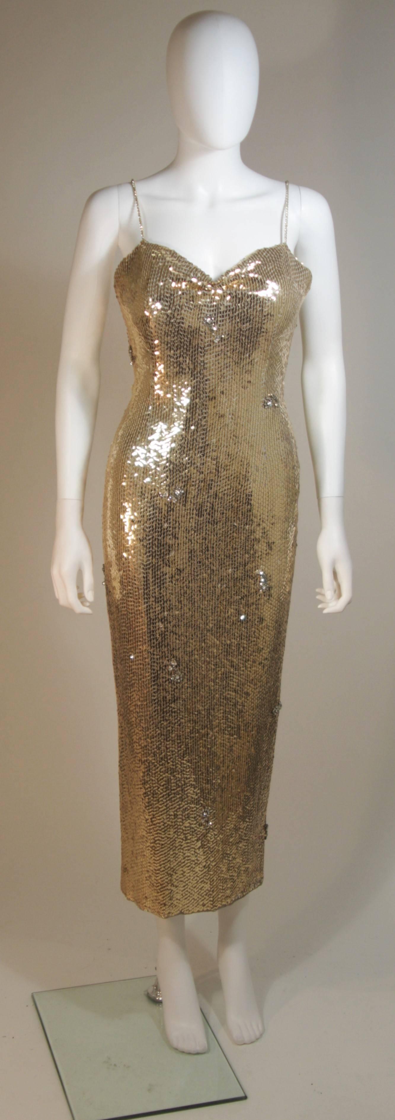 This ELIZABETH MASON COUTURE  gown is Originally from the 1960s however I  reinterpreted with my design team to give in a sexier, more contemporary flare. 
It is composed of a gold sequin fabric with scattered clear, floral, faceted rhinestone