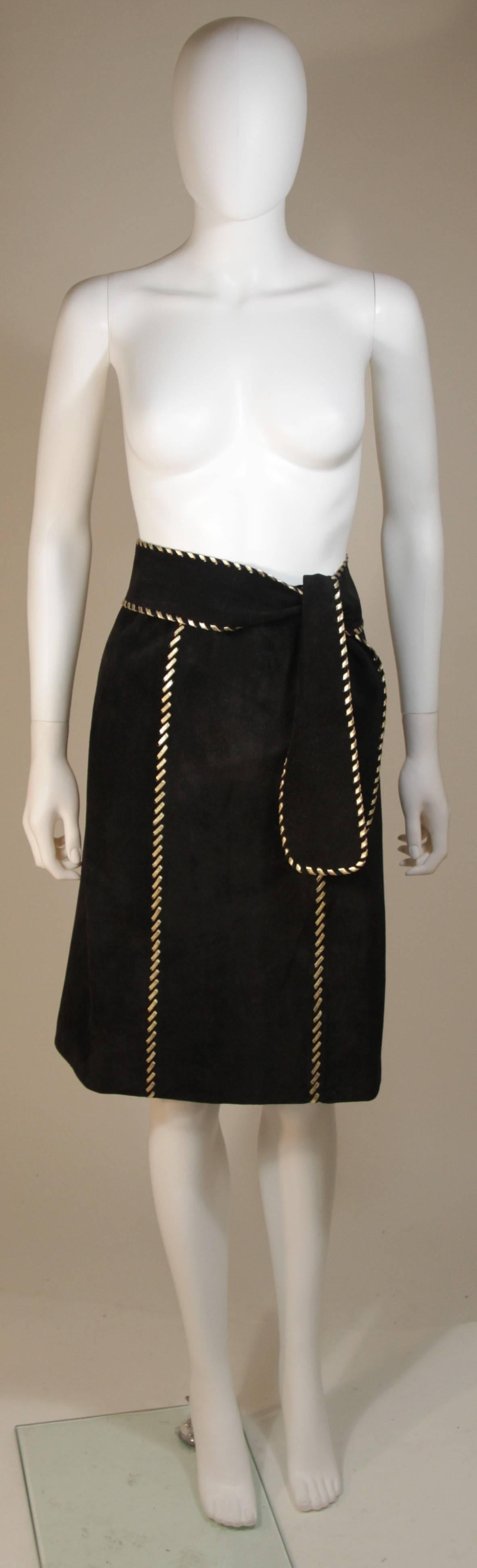 This Yves Saint Laurent  is composed of a black sueded and features gold stitch details. There is a center back zipper closure. In excellent condition, comes with belt. Made in France.

  **Please cross-reference measurements for personal