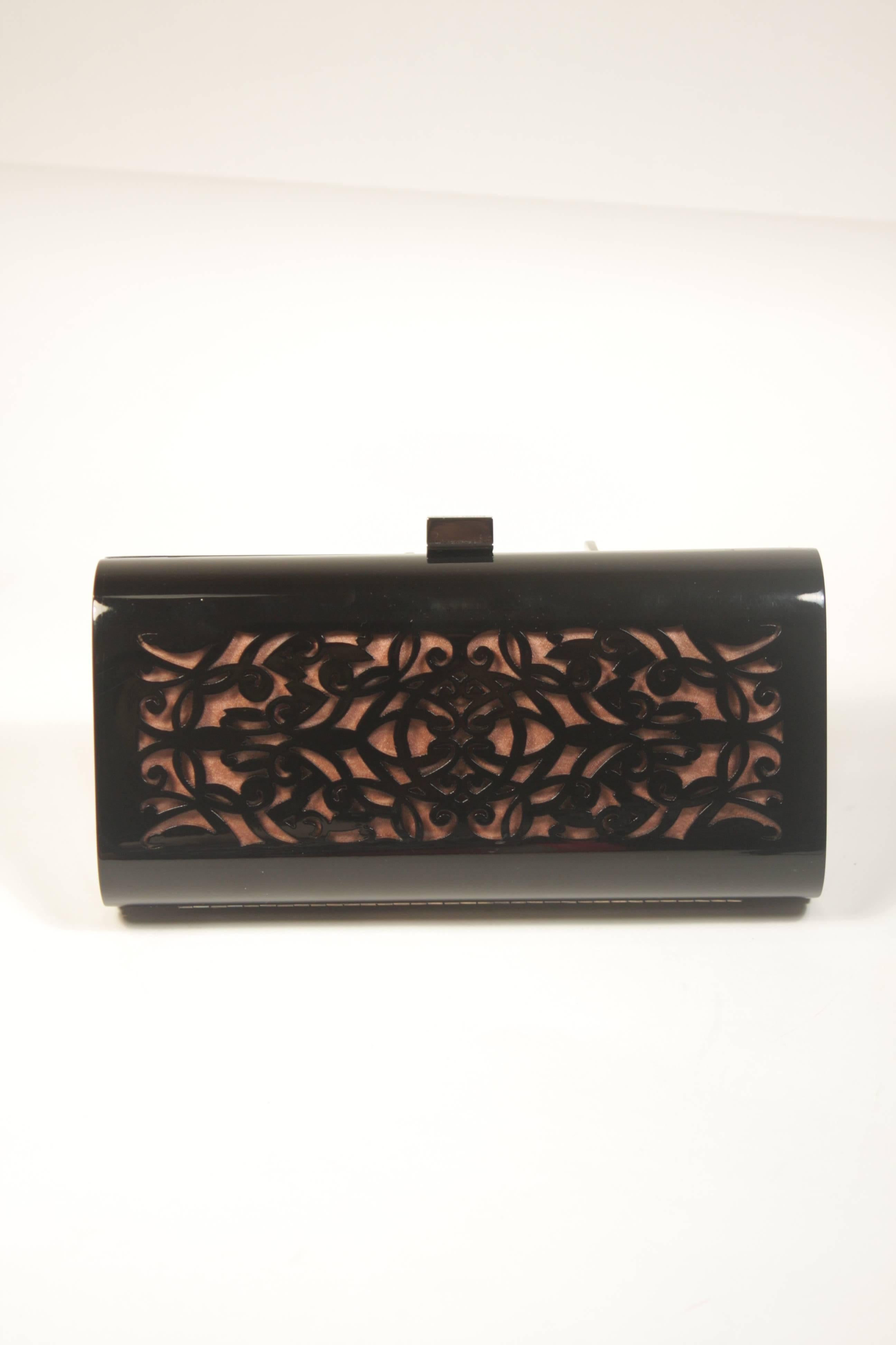 This Giorgio Armani design is available for viewing at our Beverly Hills Boutique. We offer a large selection of evening gowns and luxury garments. 

 This handbag is composed of a laser cut plastic. There is an optional strap and magnetic