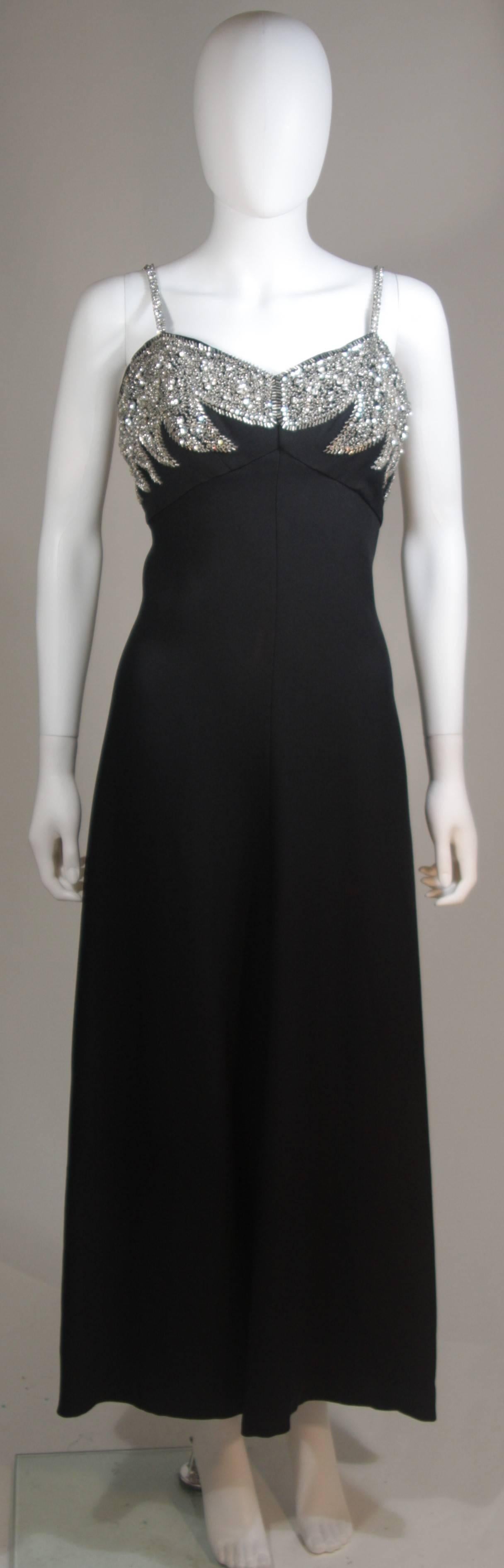  Cette robe est composée d'un tissu noir incrusté de magnifiques strass au niveau du buste et des bretelles spaghetti. La robe se ferme par une fermeture éclair au centre du dos. Vintage, en excellent état. 

  **Veuillez croiser les mesures pour