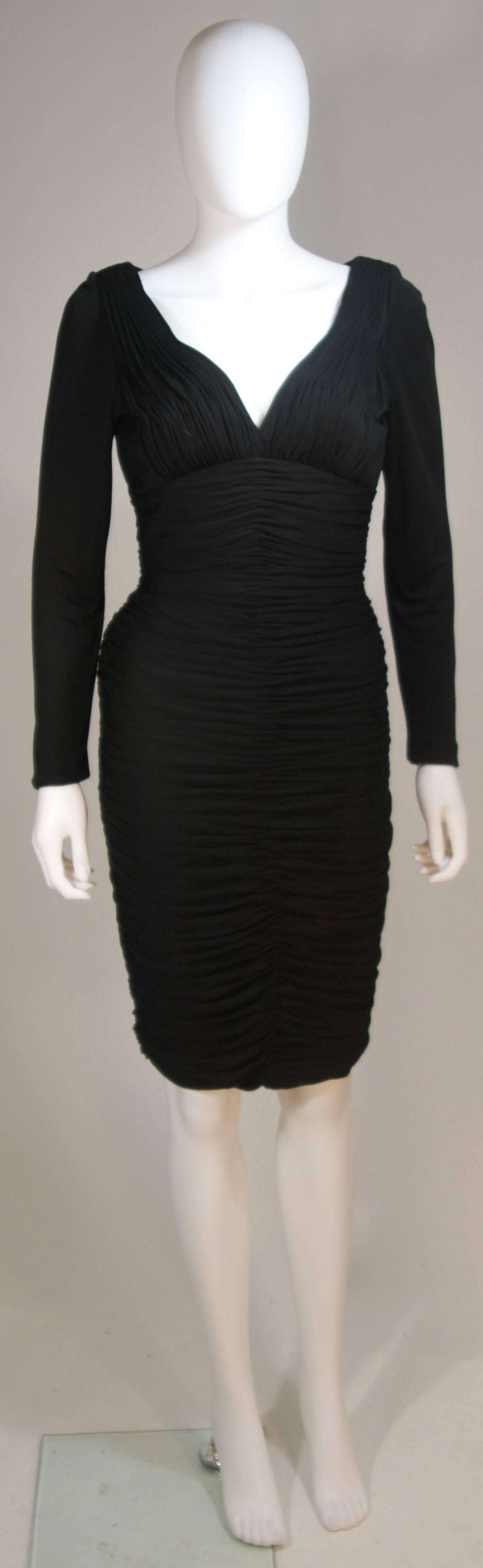  This Vicky Tiel  cocktail dress is composed of a black jersey. This dress features long sleeves and rouching. There is a center back zipper and boning details. In excellent great vintage condition, some pulls. 

  **Please cross-reference