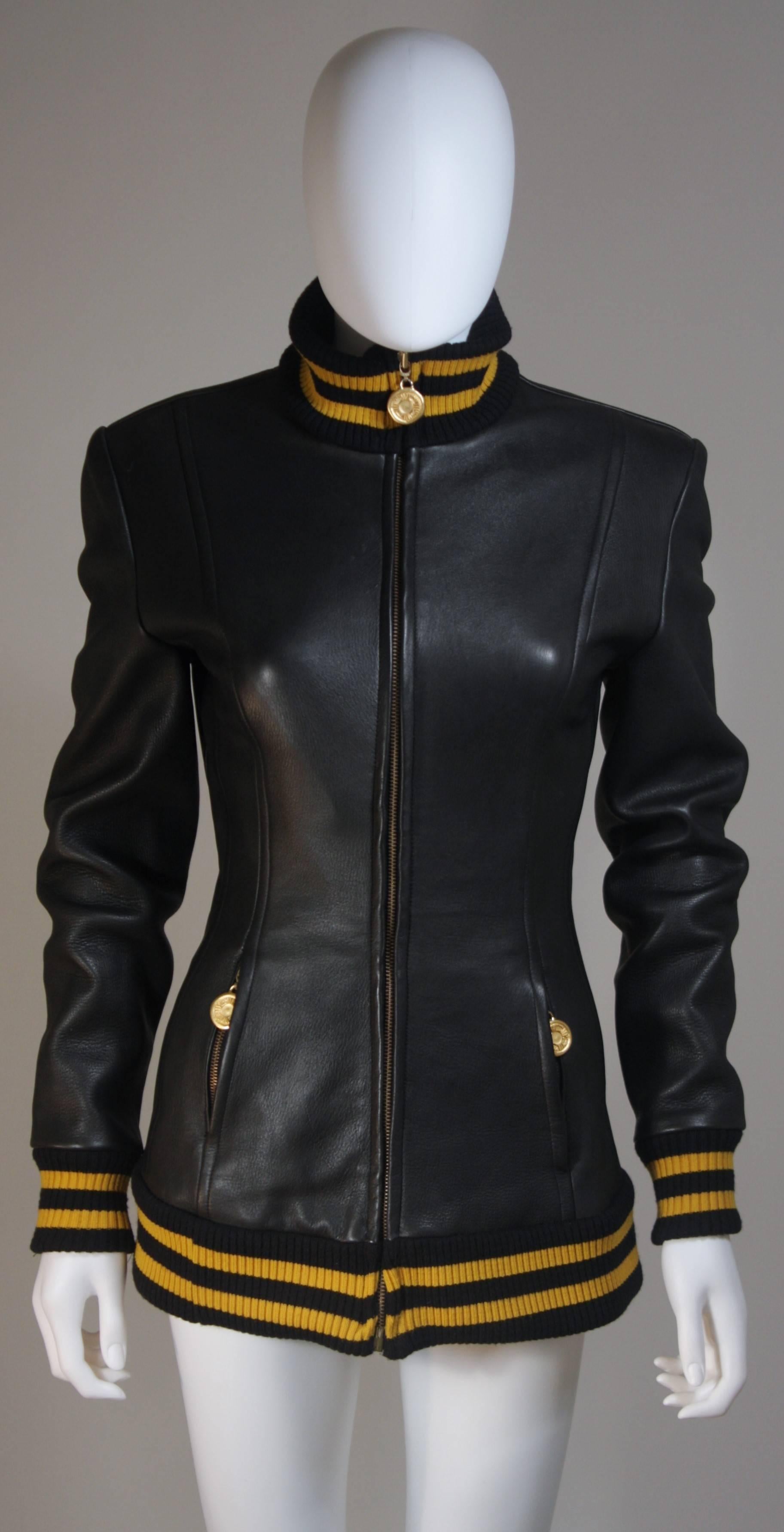  This Donna Karan New York design is available for viewing at our Beverly Hills Boutique. We offer a large selection of evening gowns and luxury garments. 

 This jacket is composed of black leather with a yellow striped ribbing at the collar,