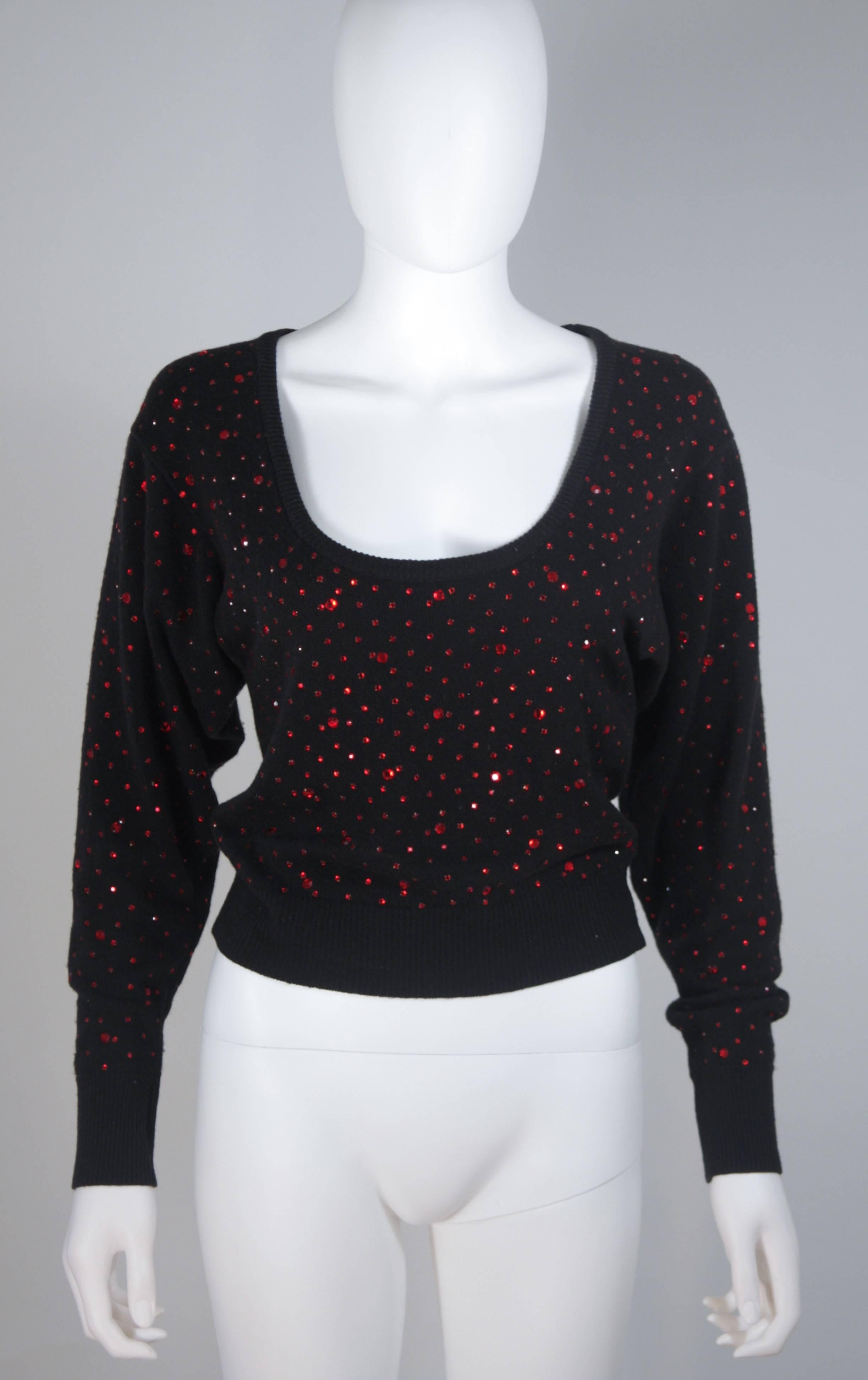 This sweater is composed of a black stretch wool and features red rhinestone applique. The large scoop neck is complimented by classic sleeve and waist ribbed detail. In great vintage condition. 

  **Please cross-reference measurements for