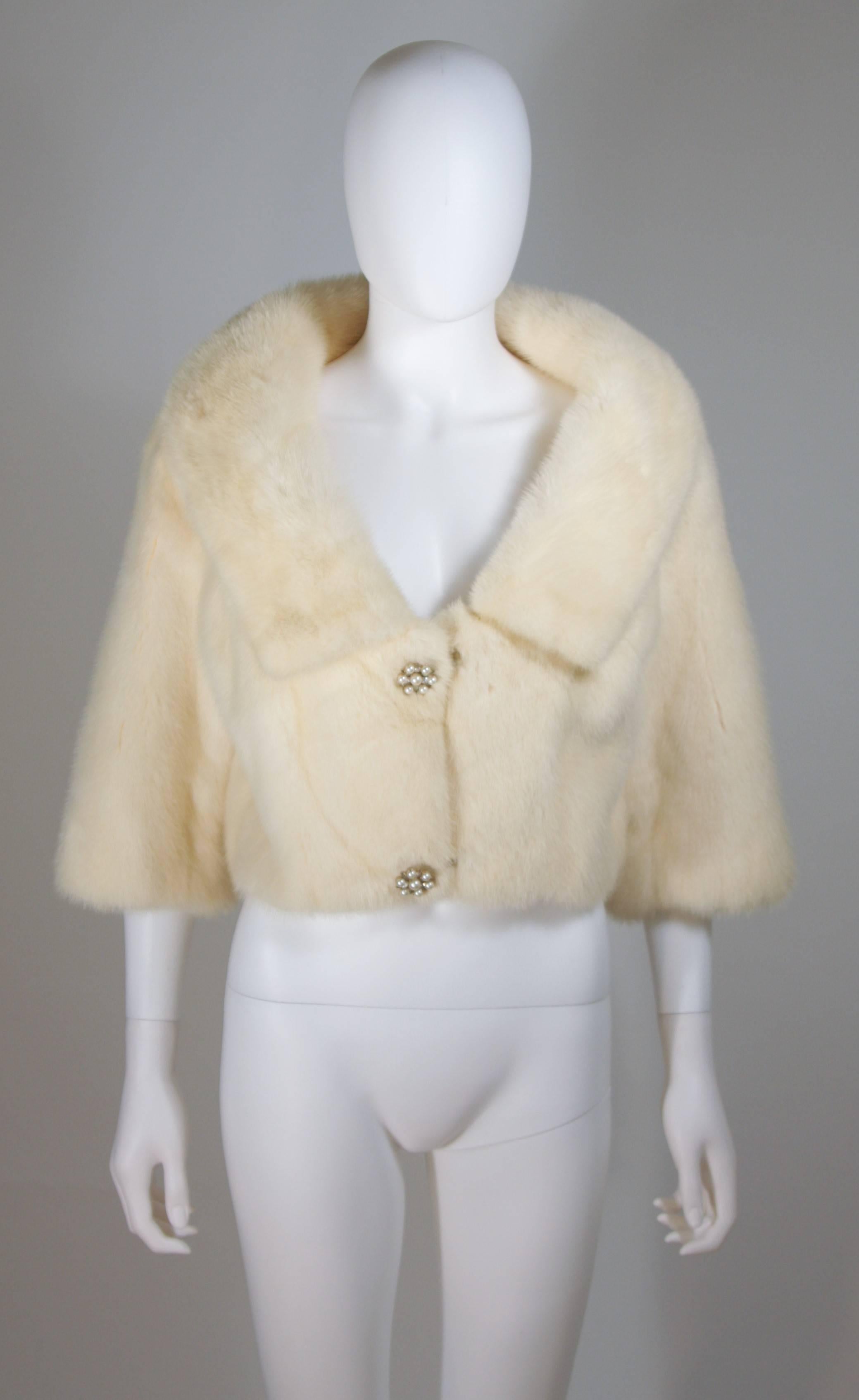  This Oleg Cassini jacket is composed of an off-white/cream hue mink. Features large rhinestone and faux pearl buttons. In excellent vintage condition, the lining does have some discoloration due to age. 

  **Please cross-reference measurements