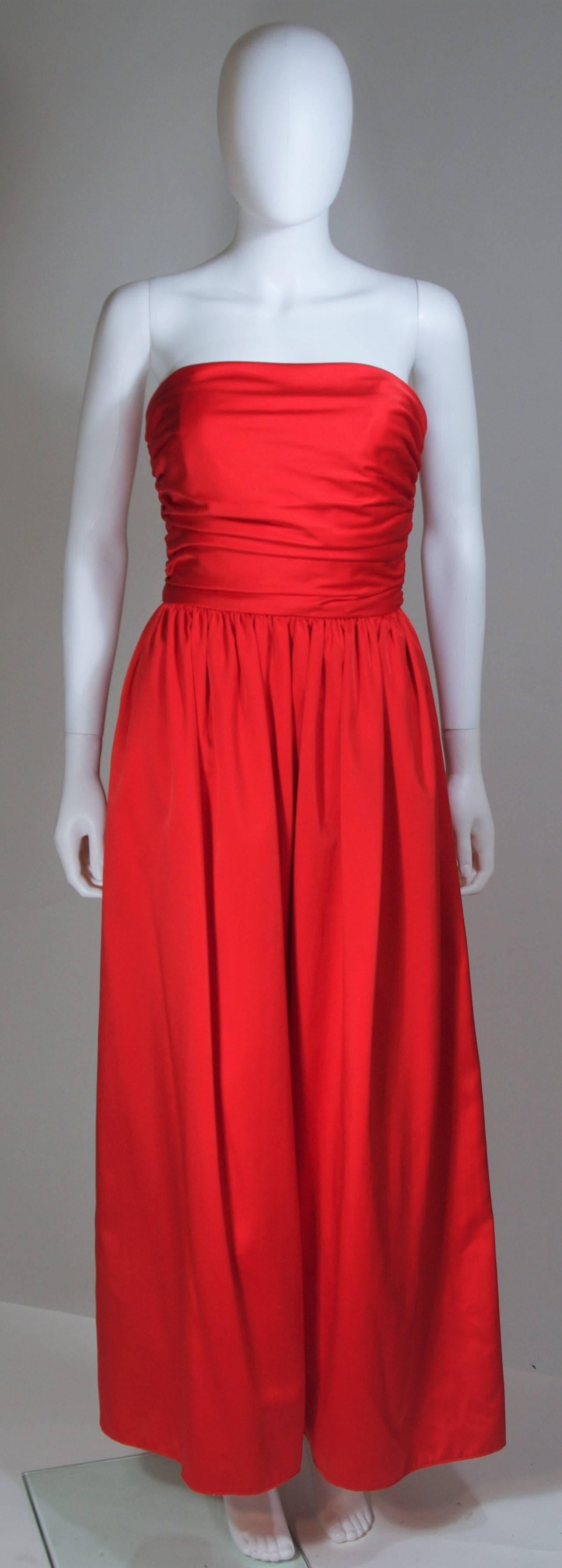  Dieses Kleid von Anthony Muto besteht aus roter Seide mit gerafftem Mieder und vollem Rockteil. Mit Bindeband in der Taille und Reißverschluss hinten in der Mitte. In ausgezeichnetem Vintage-Zustand. 

**Bitte vergleichen Sie die Maße für Ihre