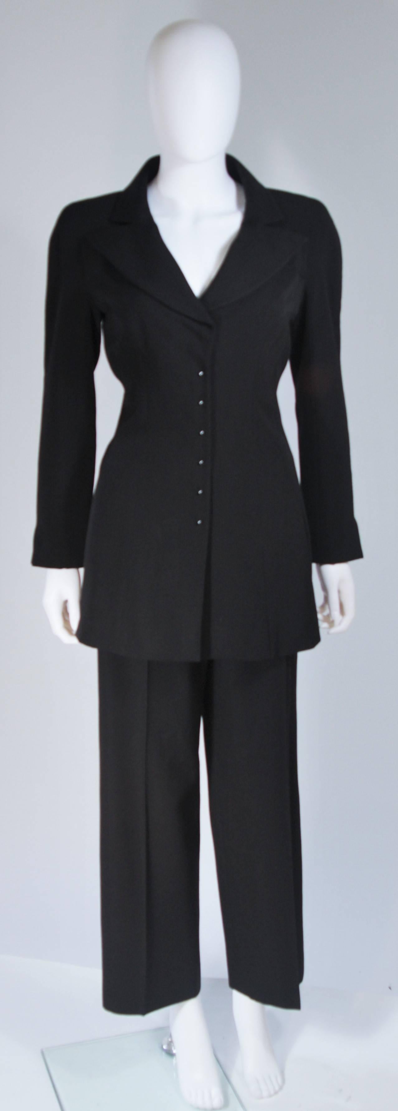  This Chanel pant suit is composed of a black blend fabric. The jacket features center front button closures and pockets. The pants feature a slack style with pressed front, center front zipper, and side pockets. In excellent condition. 

**Please