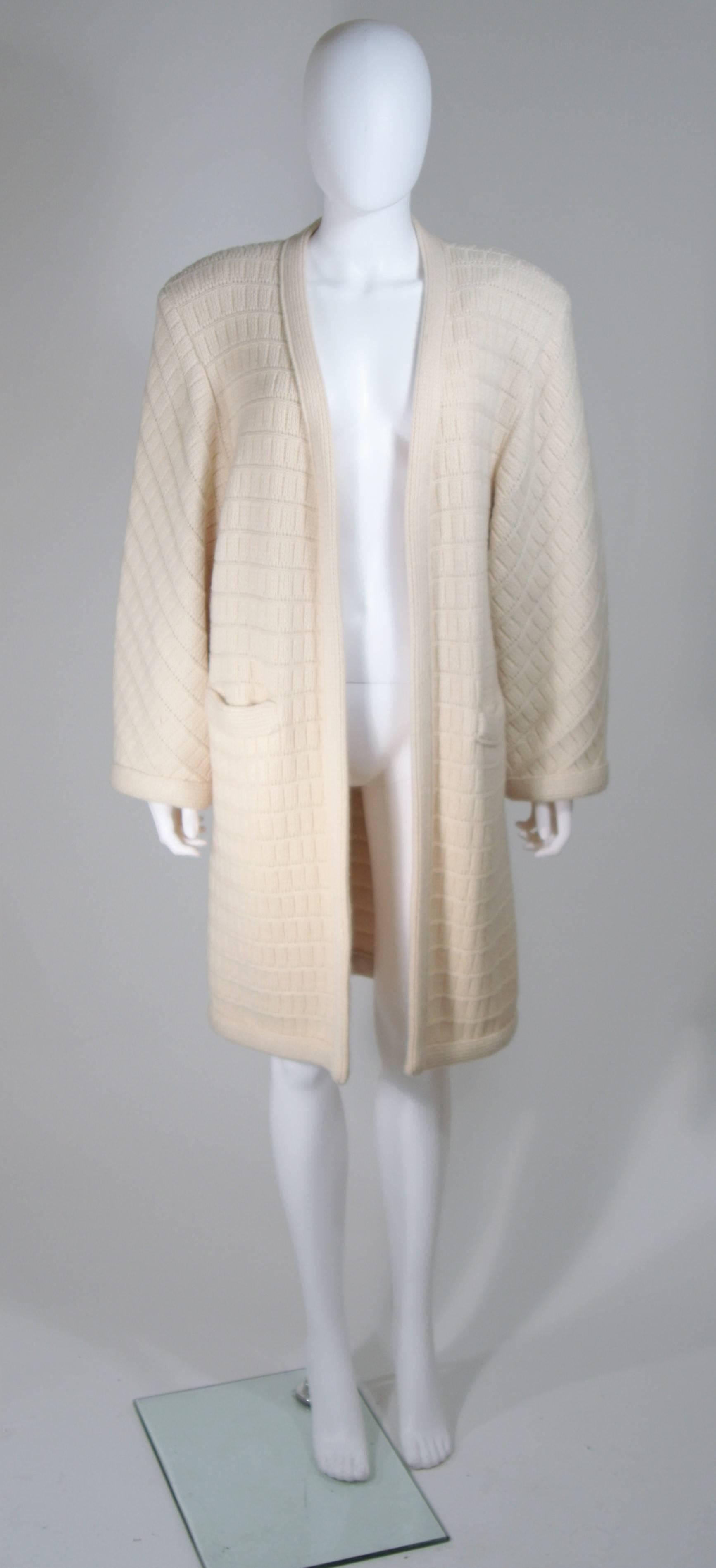   This Valentino  coat is composed of a cream knit cashmere. Features front pockets, shoulder pads (which can be easily removed) and an open style design. In excellent vintage condition. 

  **Please cross-reference measurements for personal