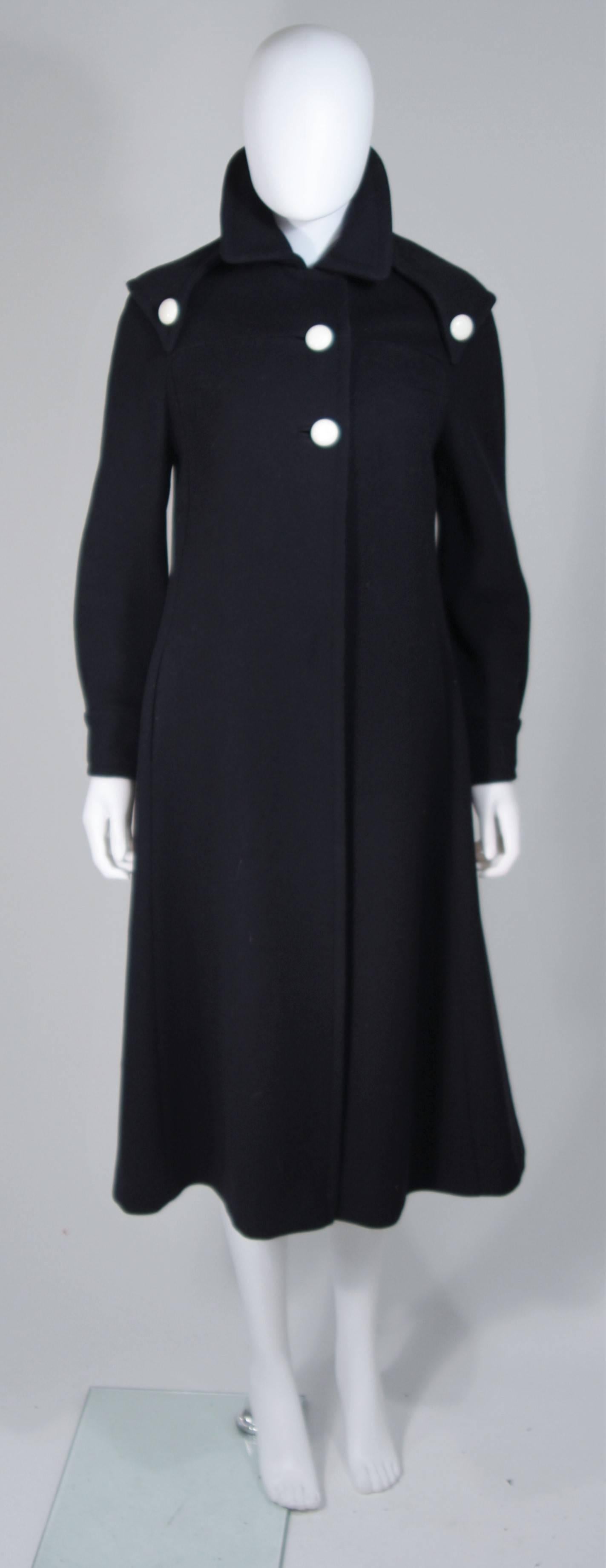   This Cuddle Coat is composed of a navy wool with white button accents. Features center front buttons and side pockets. In excellent vintage condition. 

**Please cross-reference measurements for personal accuracy. Size in description box is an