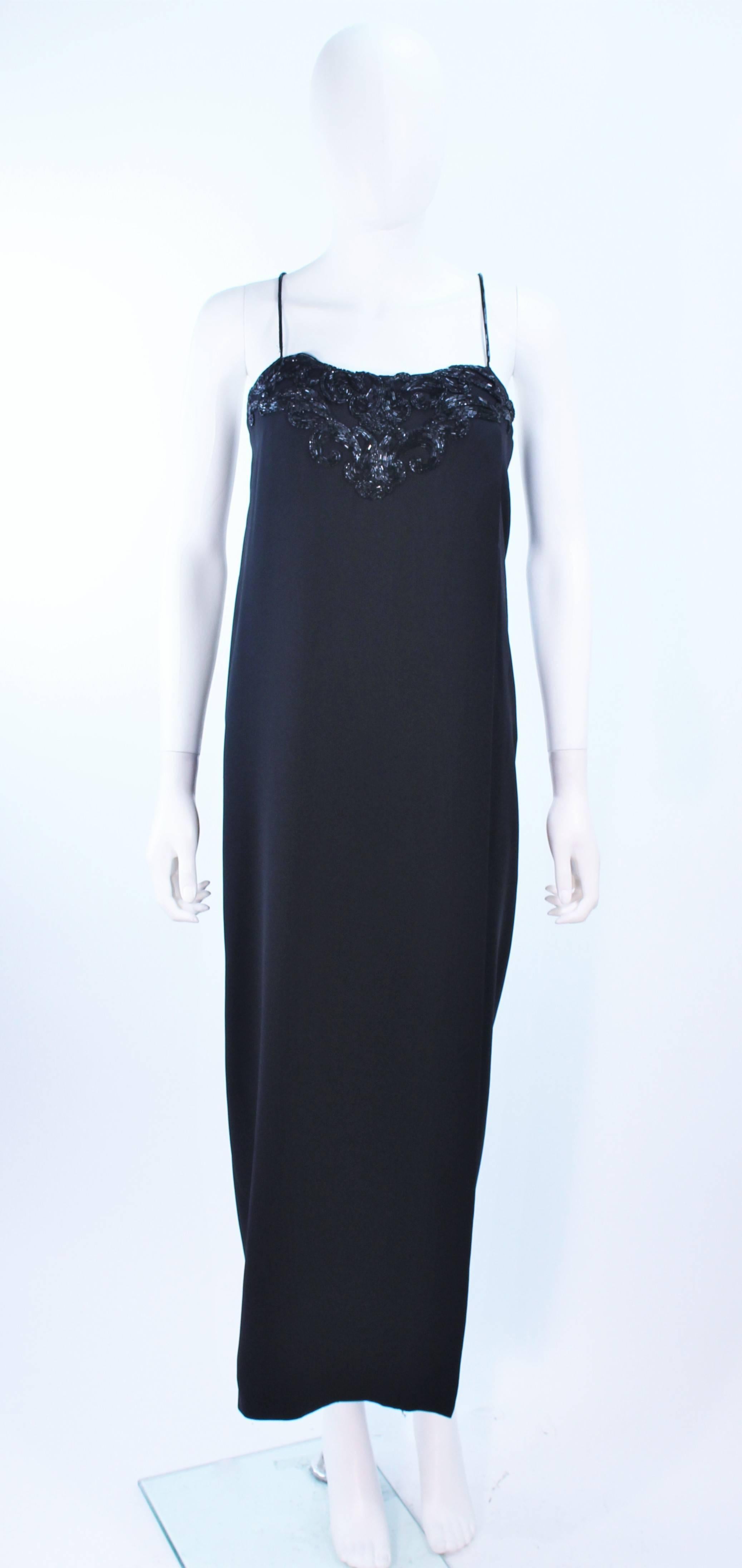Este vestido de Stavropoulos está compuesto por una gasa de seda negra y presenta un busto de cuentas con tirantes. Tiene un cierre de cremallera central en la espalda. En muy buen estado vintage, faltan algunas cuentas, en general buen