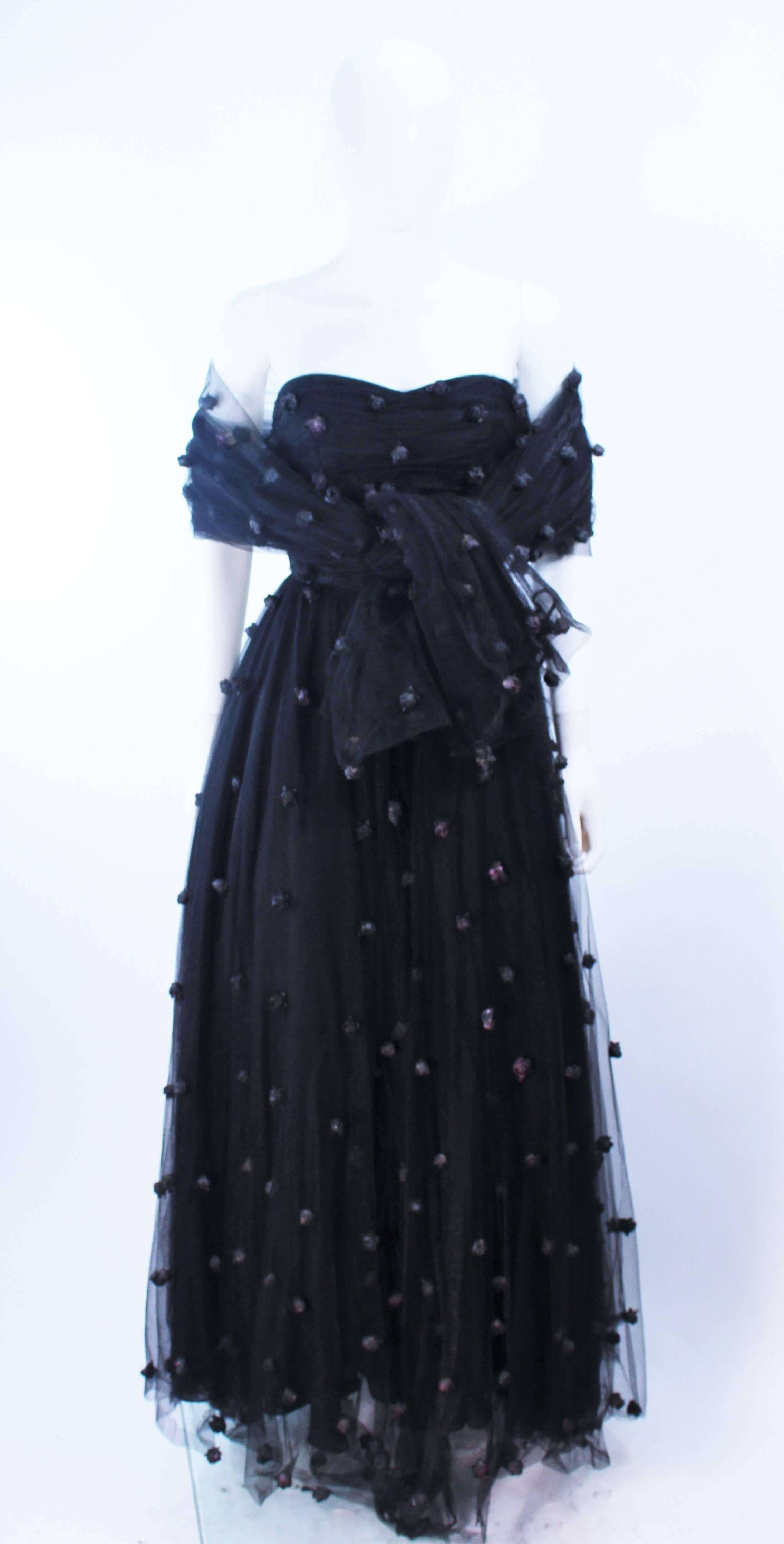 Cette robe attribuée par Pamela Dennis est composée d'une maille noire avec des applications de roses. Il y a une fermeture à glissière au centre du dos. En excellent état vintage, l'étiquette est manquante.

**Veuillez croiser les mesures pour