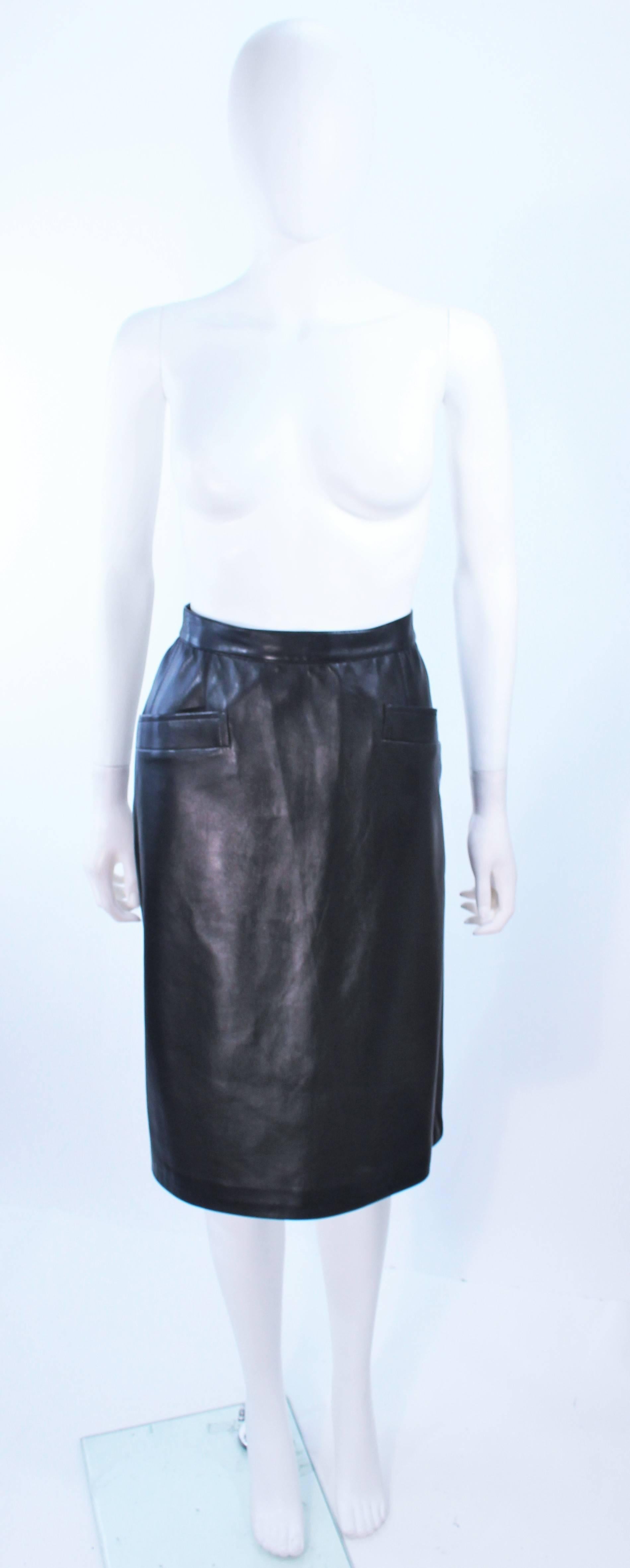 This Yves Saint Laurent skirt is composed of black leather. Features a pencil  silhouette with front pocket applique. There is a zipper closure. In excellent vintage condition.

**Please cross-reference measurements for personal accuracy. Size in