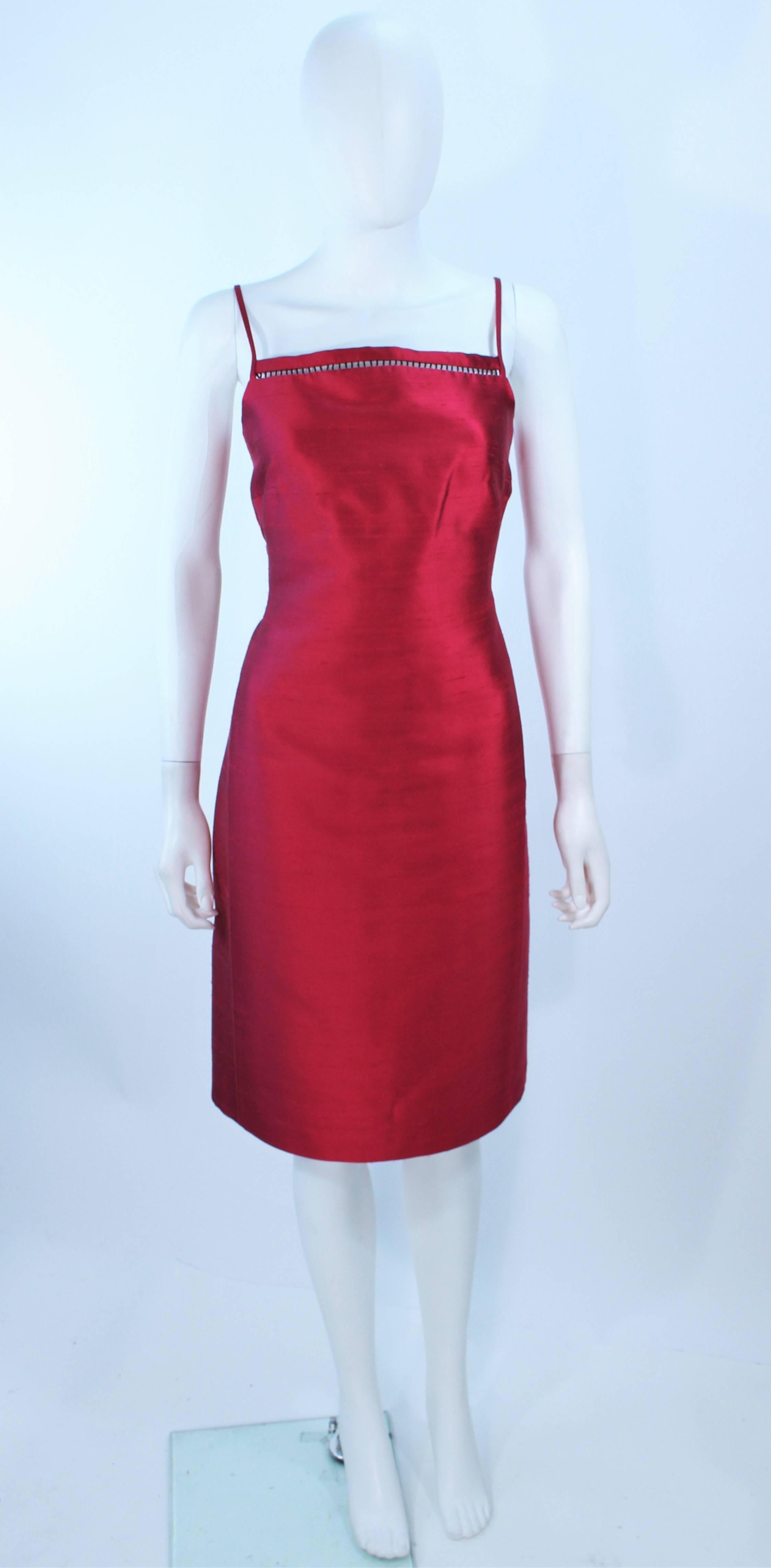 This Oscar De La Renta cocktail dress is composed of a red silk in a cranberry hue. Features a black beaded bust detail. There is a center back zipper clousure. In excellent pre-owned condition.

**Please cross-reference measurements for personal