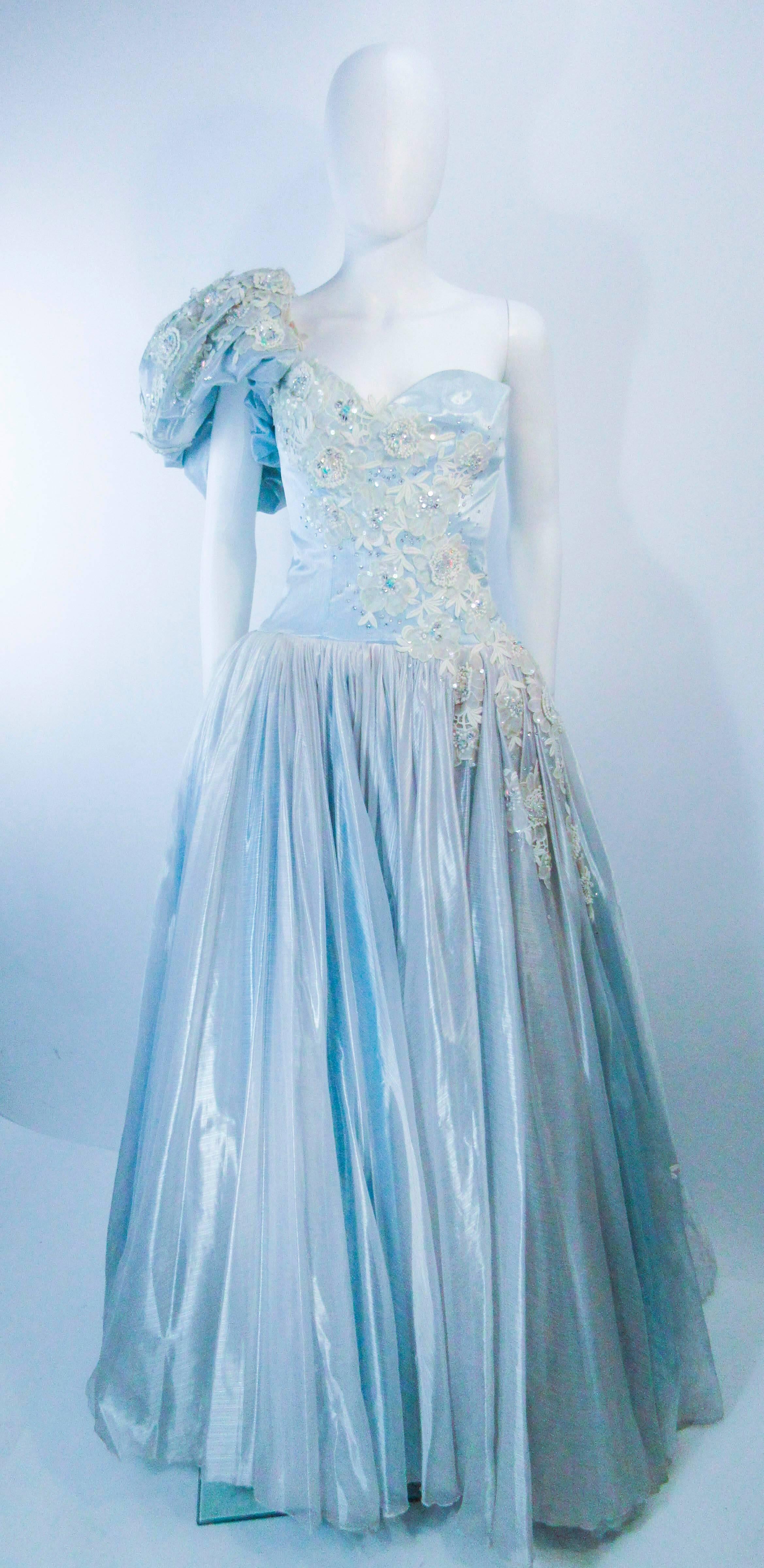 This Nolan Miller gown is composed of a sky blue and white combination. The upper bodice features a lace embellished center front and puff sleeve. In great  vintage condition with some signs of age. 

  **Please cross-reference measurements for