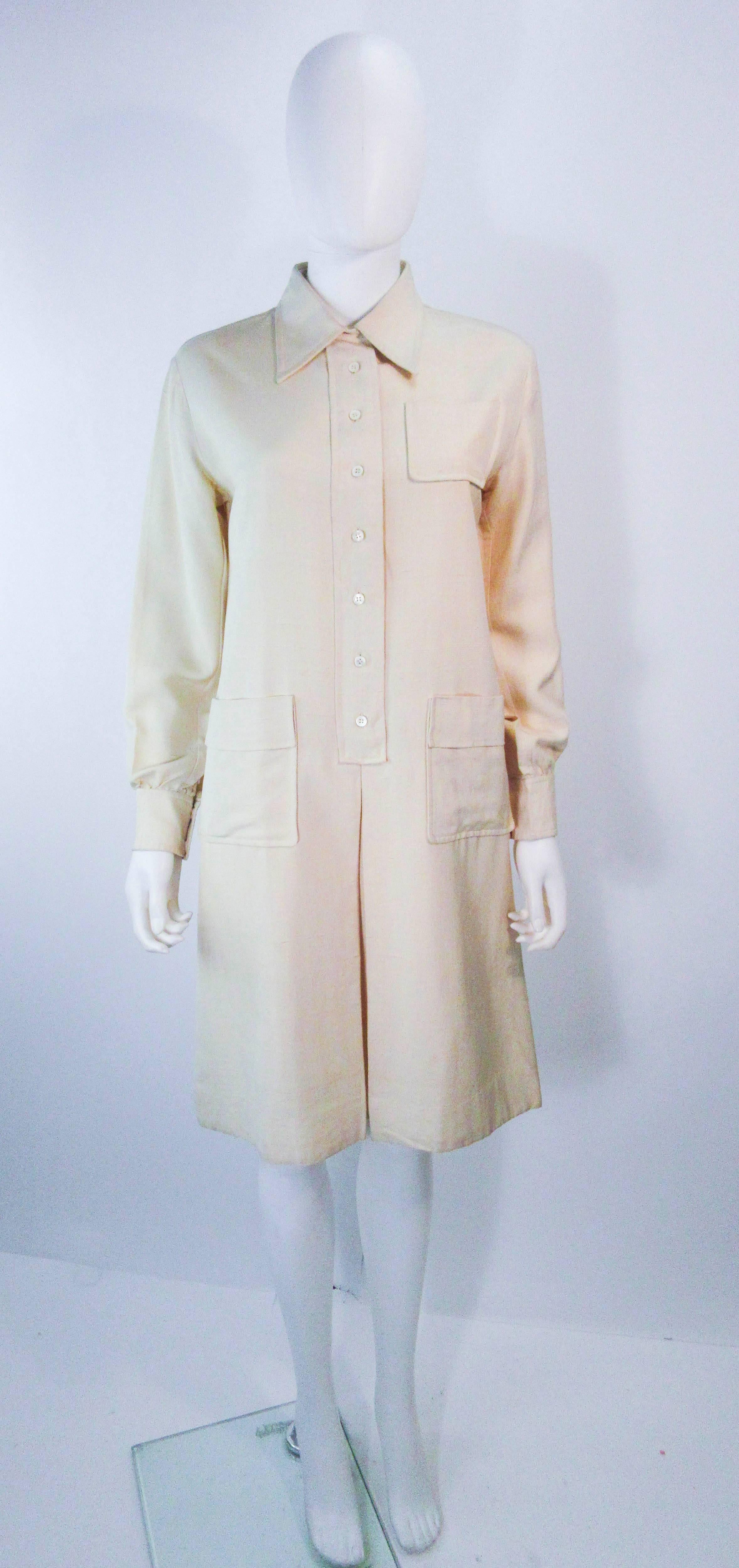 This Yves Saint Laurent dress is composed of a white linen & features a utility/safari style. There are center front button closures with front pockets. In great vintage condition there is some signs of wear due to age, the size and fabric content
