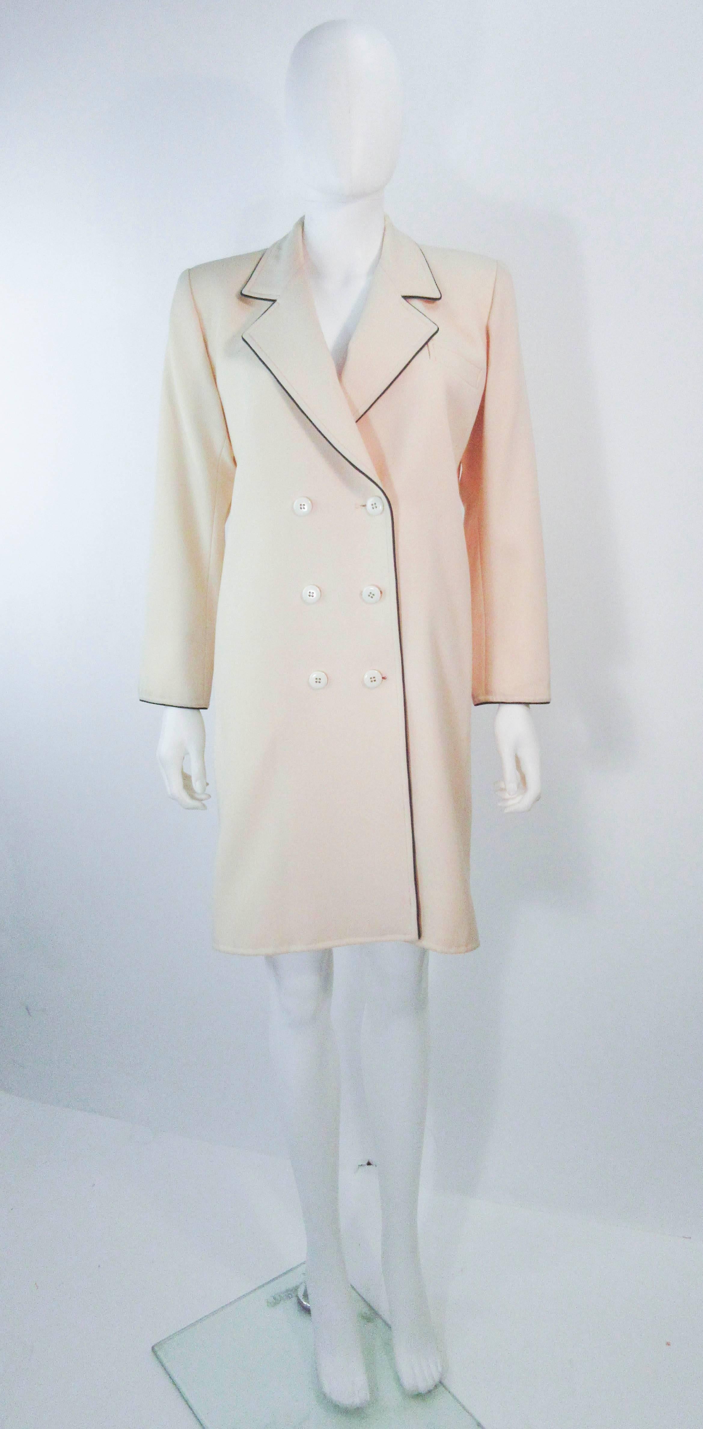This Yves Saint Laurent coat/dress is composed of a cream wool with black pipping trim. There are center front button closure. In great vintage condition there is some signs of wear due to age, the size and fabric content label are missing (have