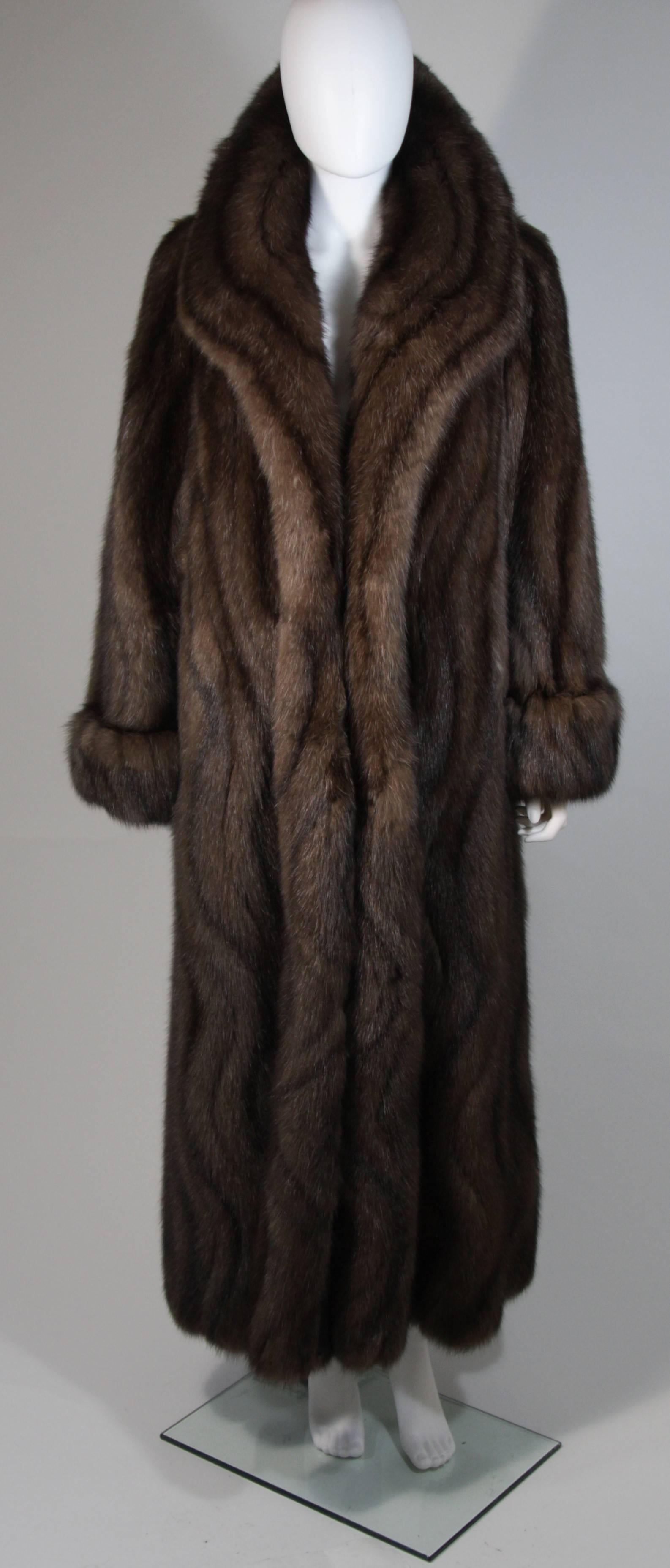 This custom Russian Sable coat is made of finest Russian Sable. This ultra supple coat features a large collar with beautifully patterned pelts that flow in a waved design. There are center front hook and closures, and side pockets. In excellent