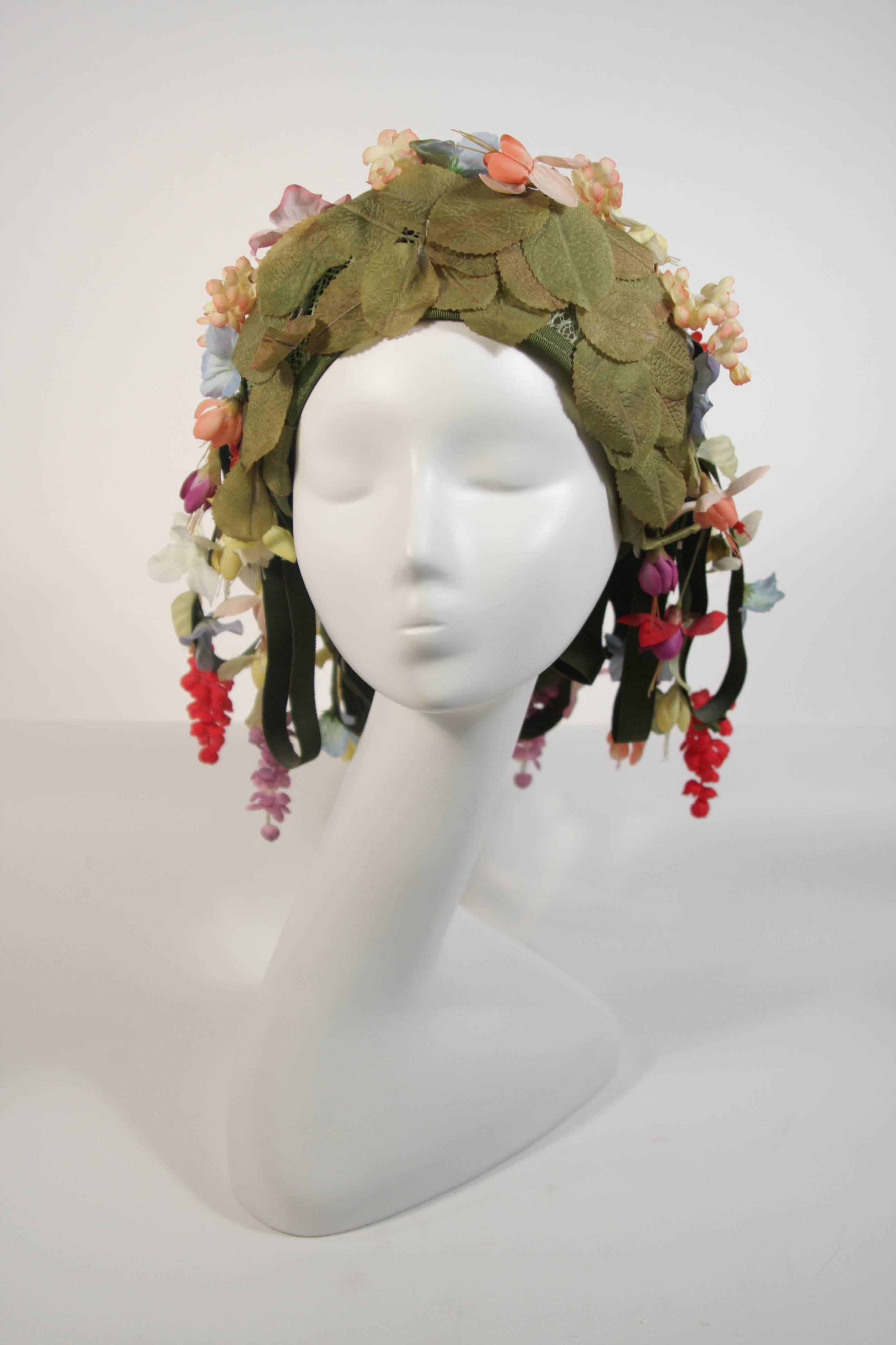 This Jack McConnell hat is composed of a green mesh foundation and features cascading green ribbons with wonderful flowers. A beautiful statement piece filled with fantasy. This hat is in great vintage condition.

**Please cross-reference