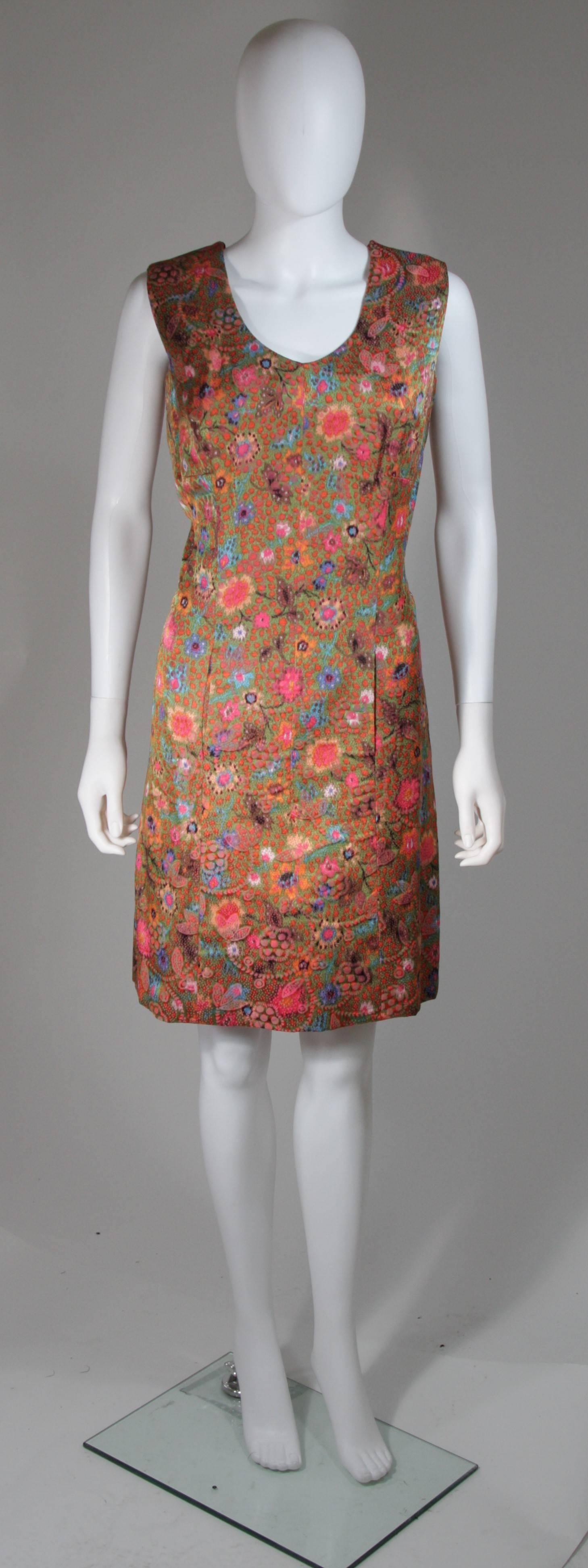 This Galanos dress is composed of a lovely and vibrant floral print fabric. It is lined with a beautiful pink silk and features a side zipper as well hook and closures on the shoulder, for ease of access. There are front pockets which align to lay