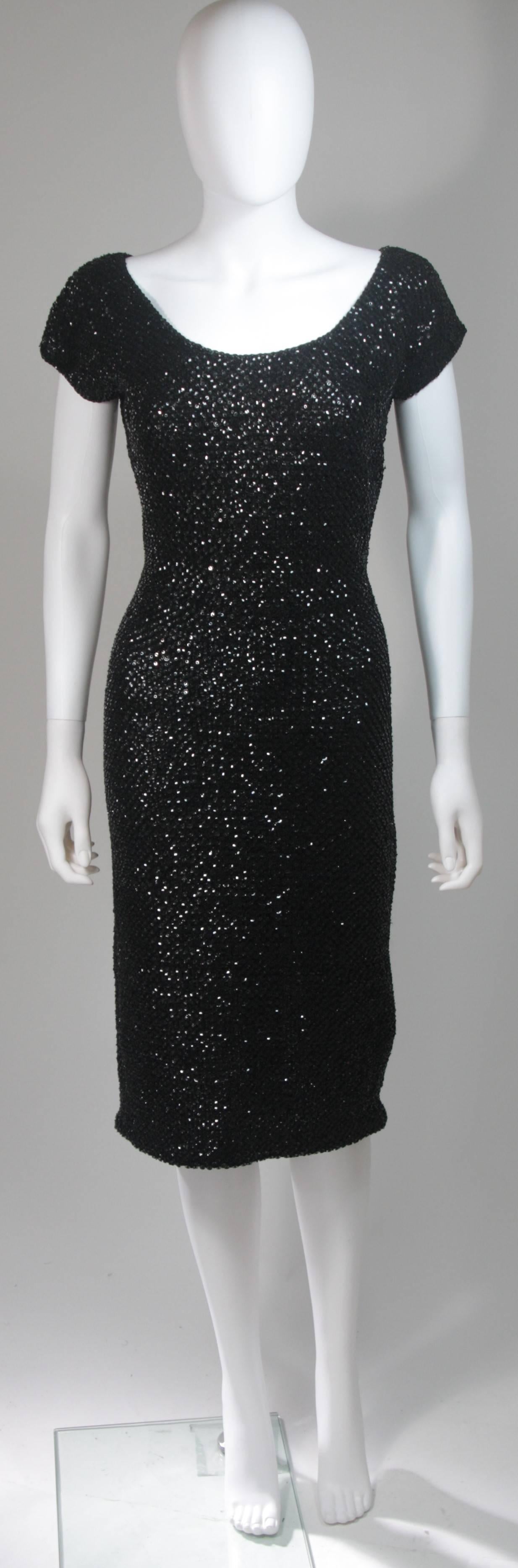 This Gene Shelly cocktail dress is fashioned from a black knit wool and features sequin embellishing throughout. The 3/4 length is complimented with a perfectly proportioned cap sleeve. There is a zipper closure. In excellent condition. Made in Hong