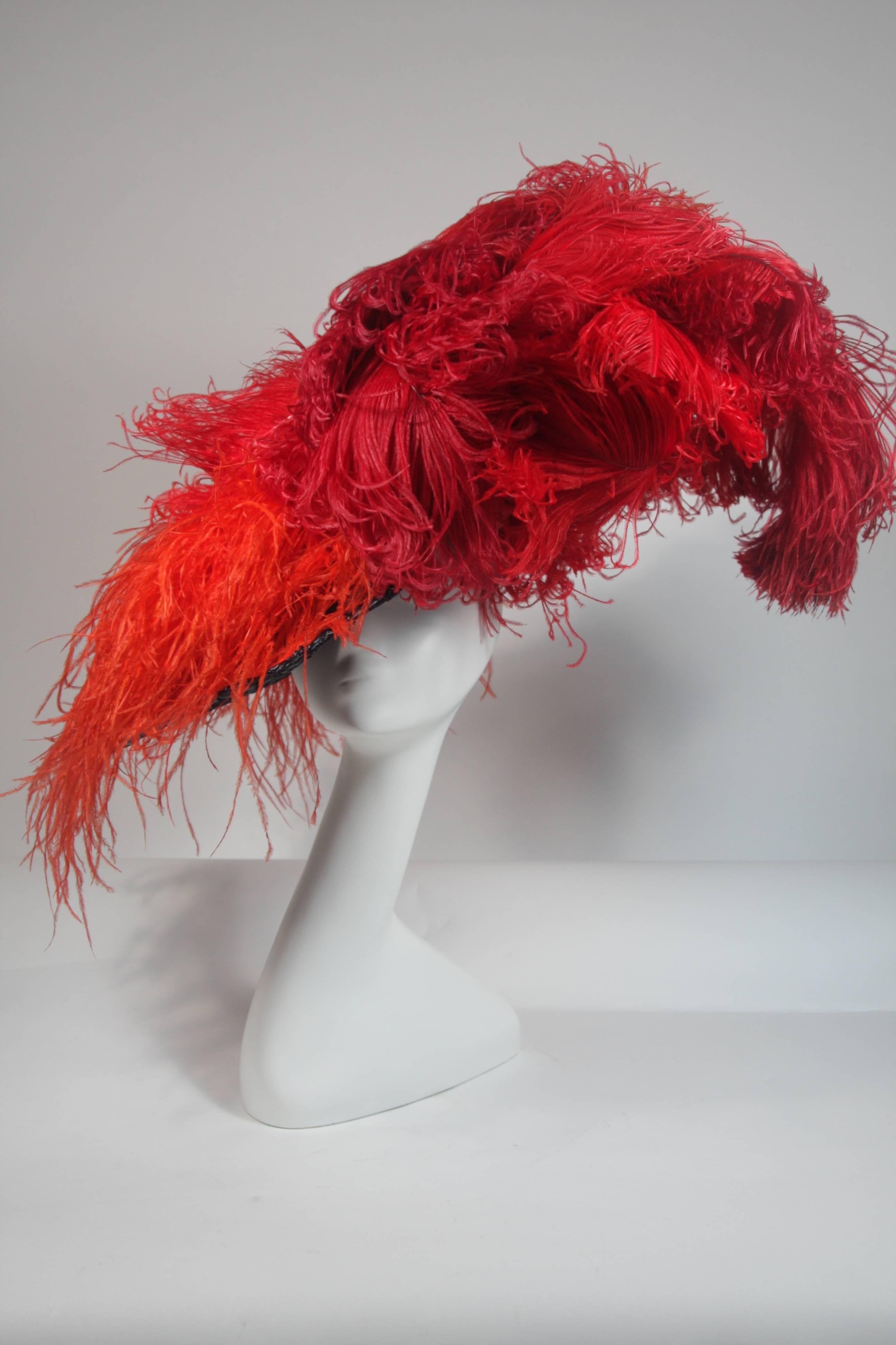 This Galanos design is available for viewing at our Beverly Hills Boutique. We offer a large selection of evening gowns and luxury garments. 

 This wonderful hat is composed of a navy synthetic rafia and features large vibrantly colored ostrich